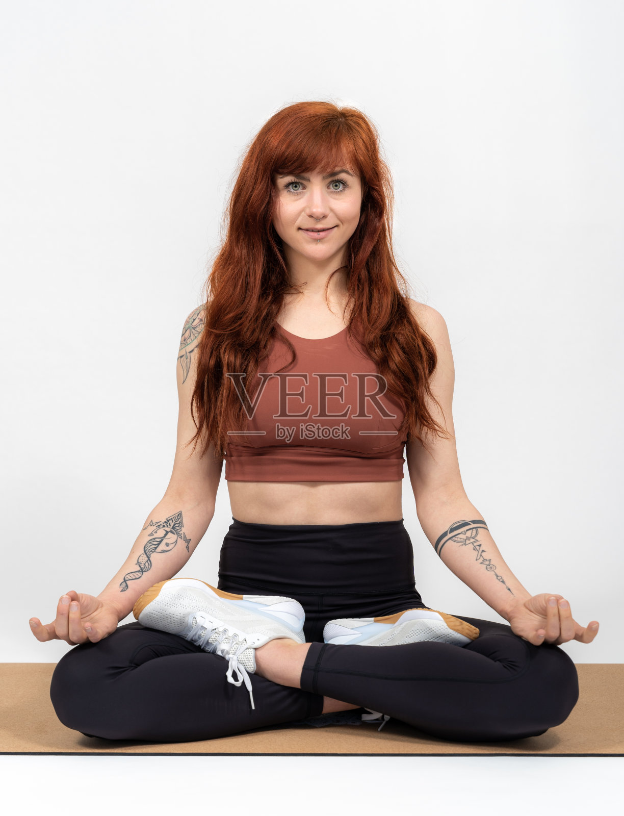 一个红头发的女孩的肖像在白色的背景在裁缝座位折叠的双手照片摄影图片