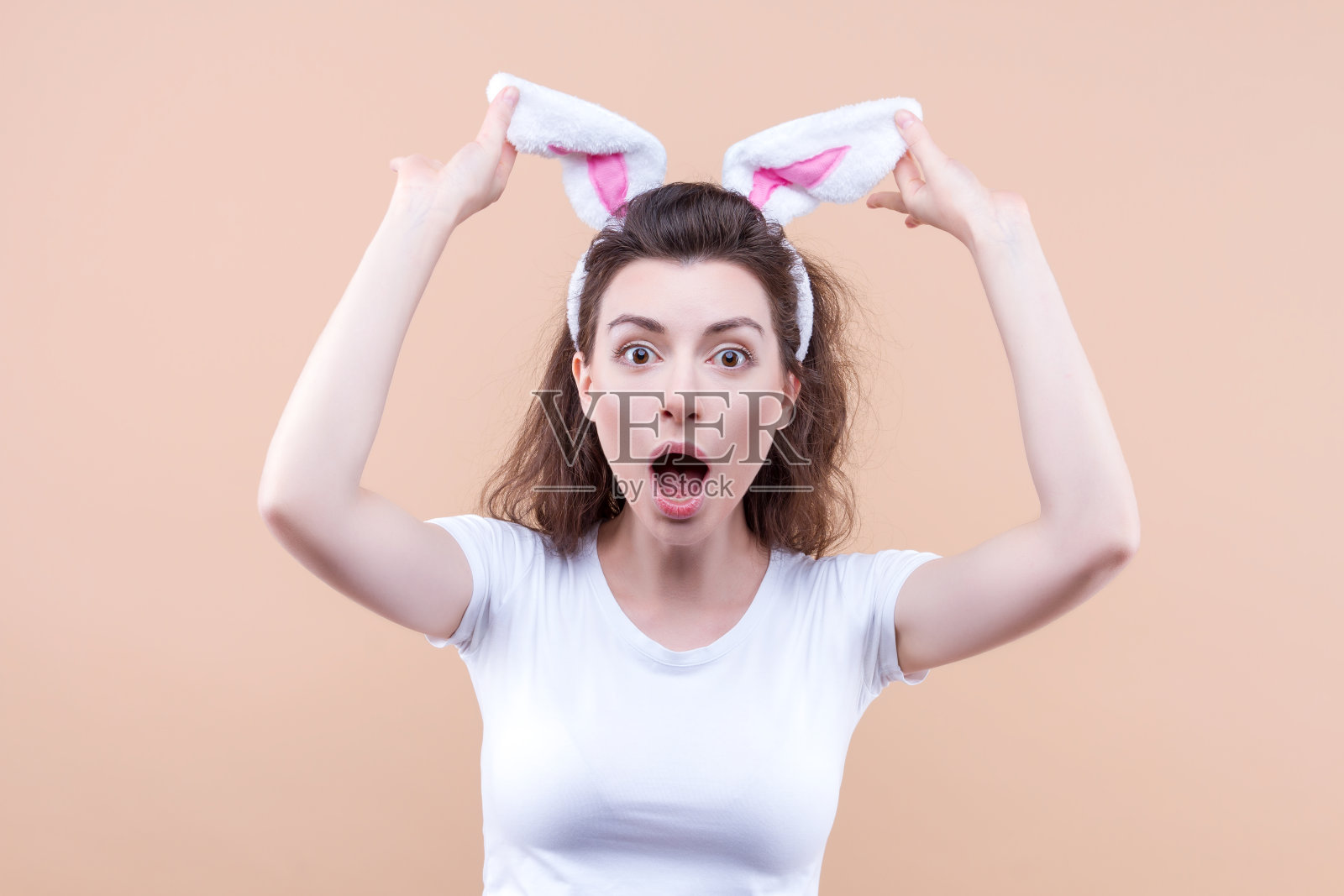 带着兔耳朵的有趣女人复活节快乐。照片摄影图片