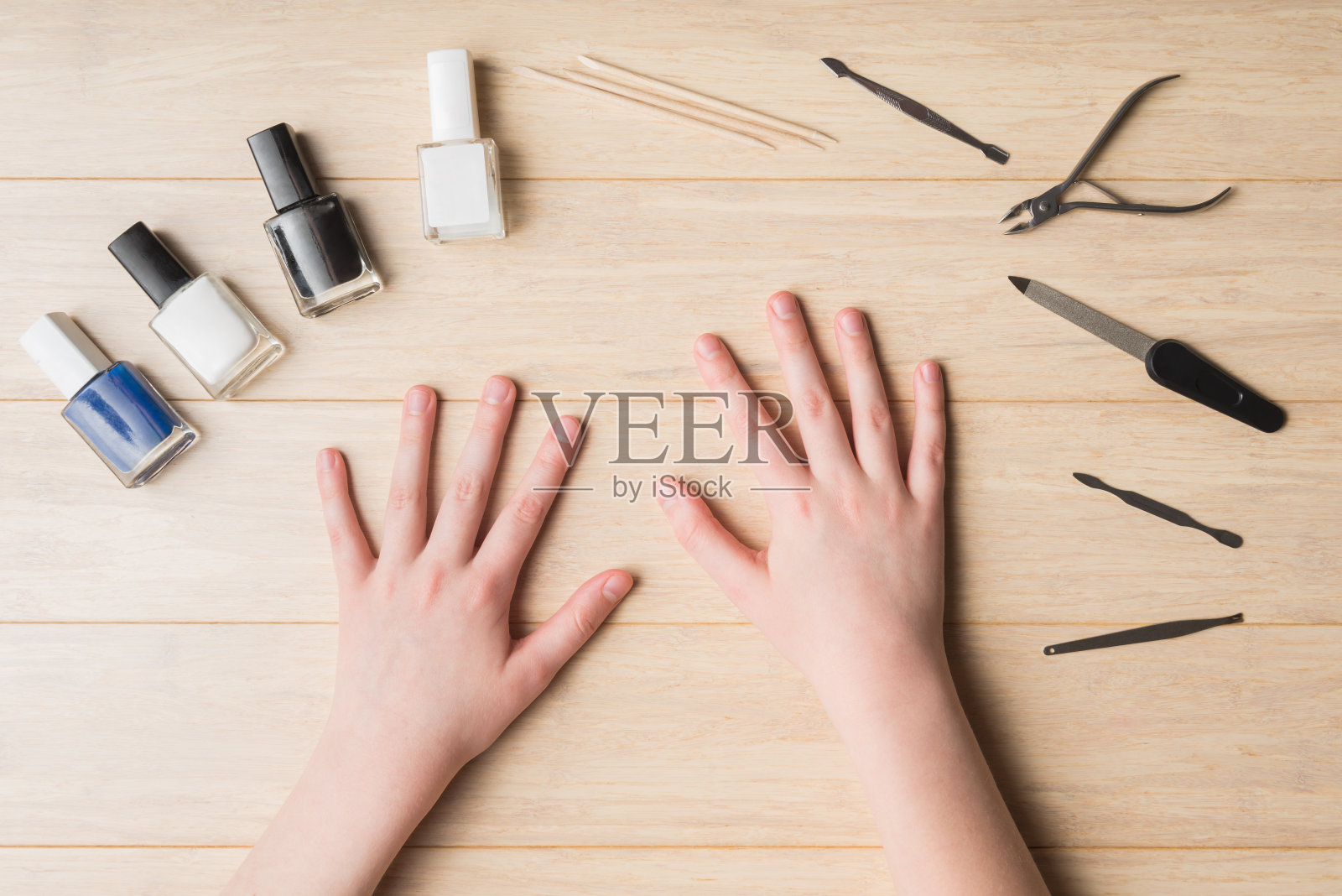 俯视图的青少年的手和美甲工具在轻木桌照片摄影图片