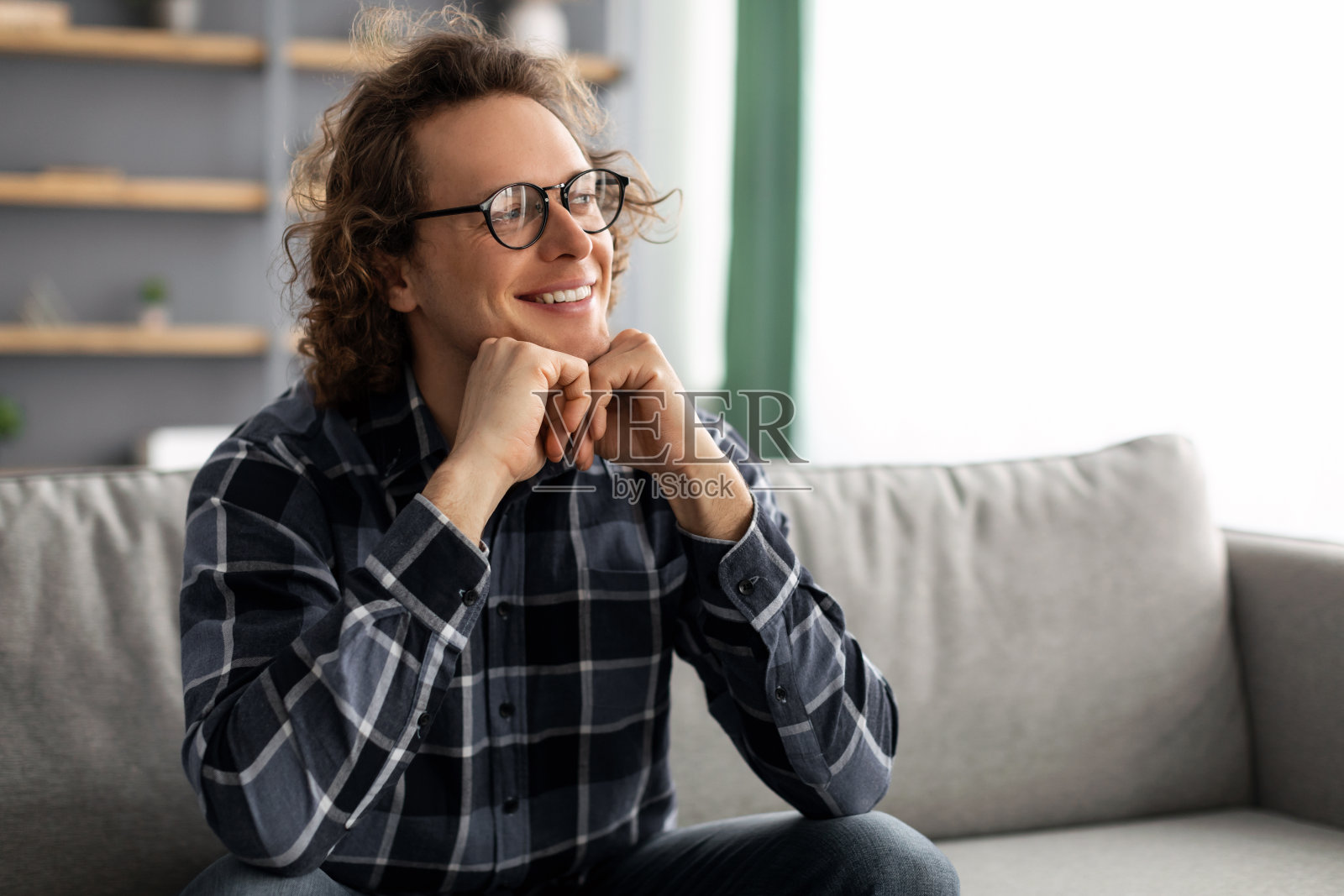 坐在沙发上思考的快乐的家伙在家照片摄影图片