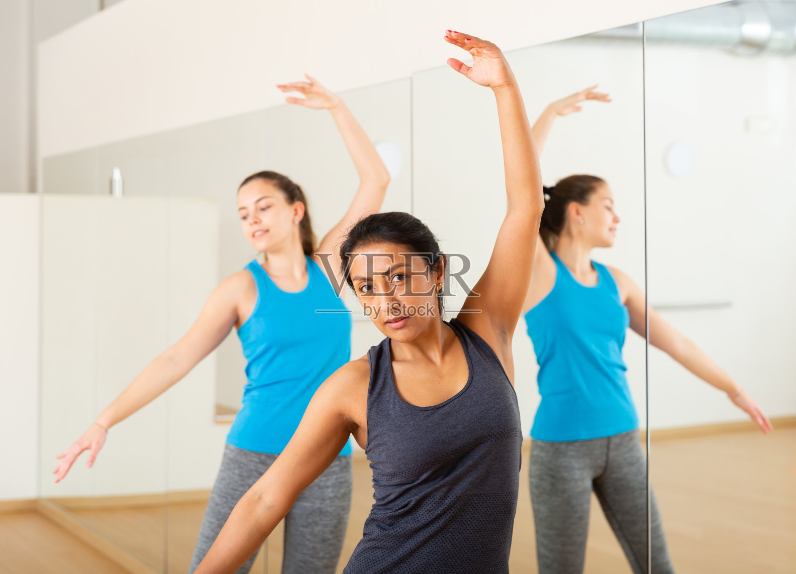 西班牙妇女练习经典的舞蹈动作在集体课照片摄影图片