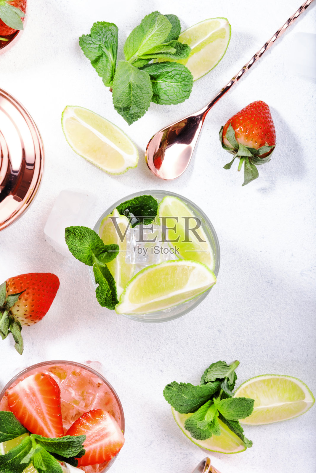 莫吉托鸡尾酒或鸡尾酒，以青柠、薄荷、草莓和冰为背景。冷酒精或非酒精饮料，饮料和鸡尾酒照片摄影图片