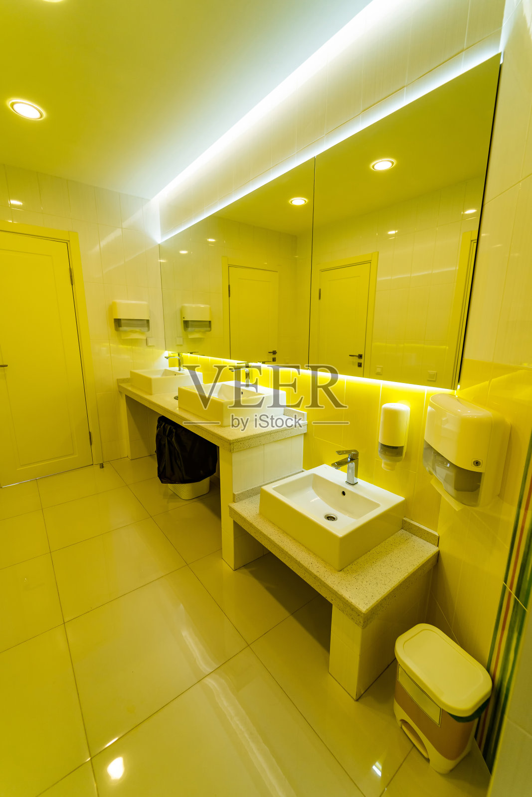 白色新的干净的方形水槽与金属闪亮的阀门水龙头在白色内部的医疗诊所。背景有一面大镜子的瓷砖墙。特写镜头。照片摄影图片