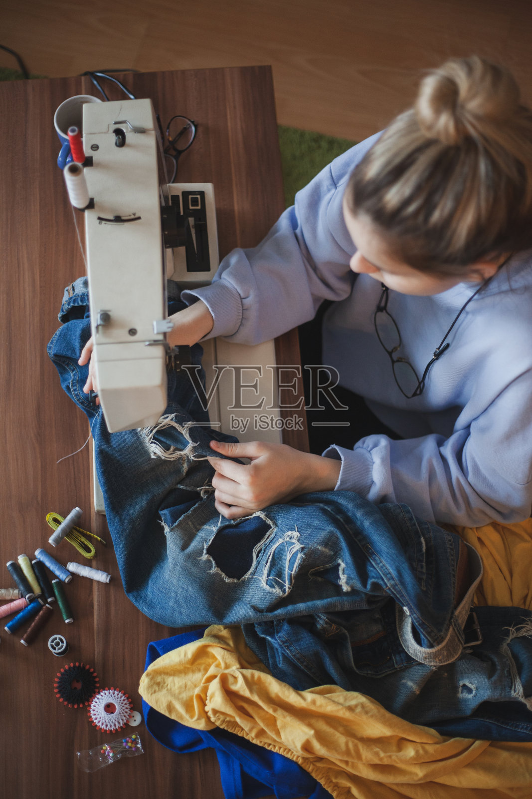 年轻的女裁缝在缝纫机上缝衣服照片摄影图片