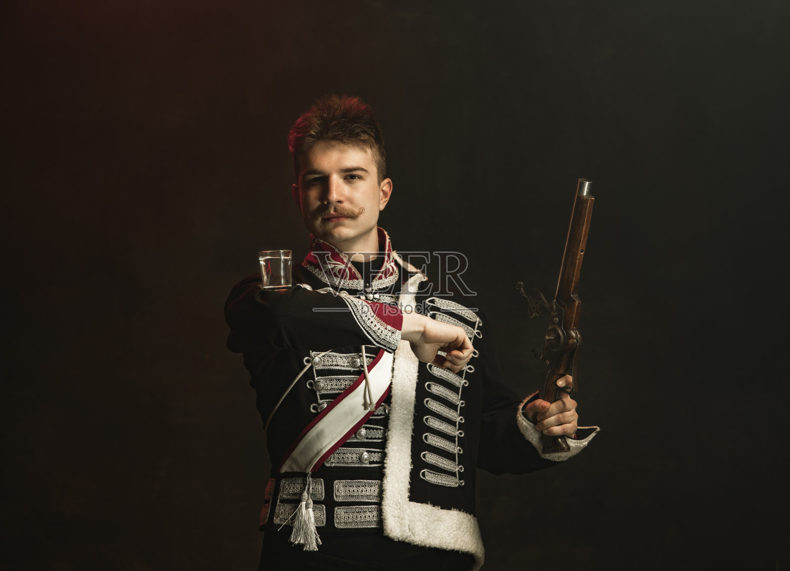 年轻男子在西装皇家人孤立在深绿色的背景。复古风格，比较时代的概念。漂亮的男模像历史人物，君主，守旧。照片摄影图片