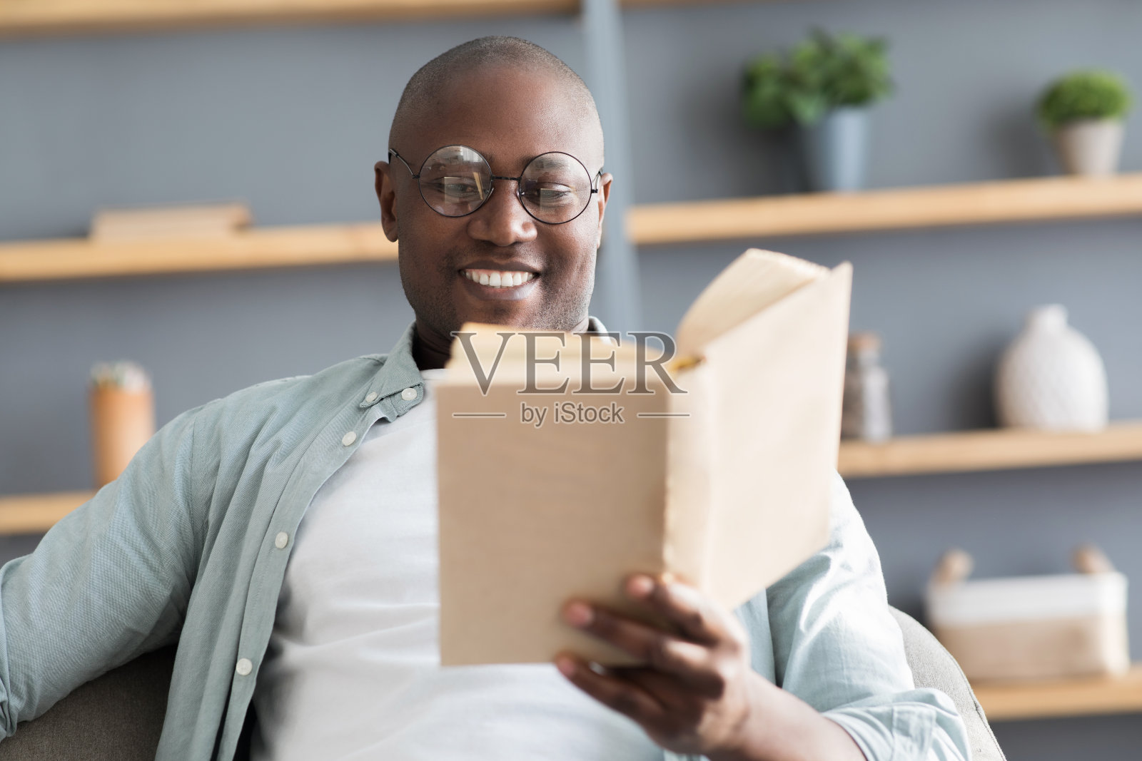 休闲的概念。黑人成熟男人读书，享受长篇小说畅销小说，有选择的焦点照片摄影图片