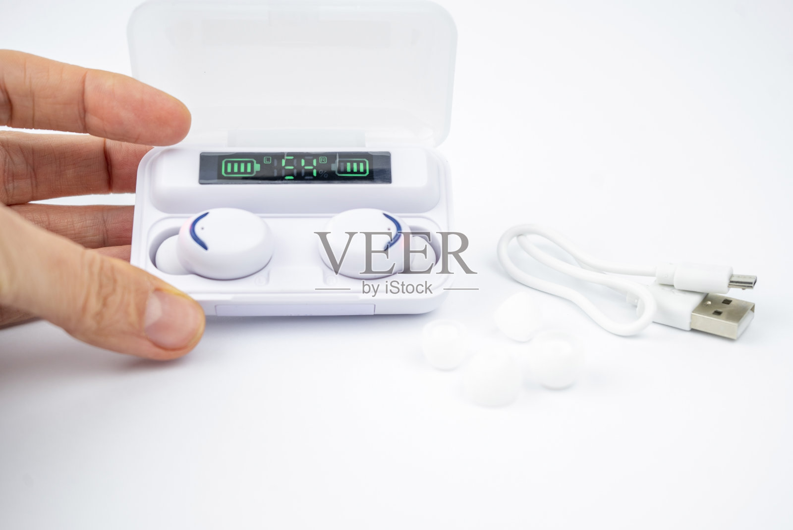 白色真实无线耳机与数字显示在塑料充电盒，隔离在白色背景照片摄影图片