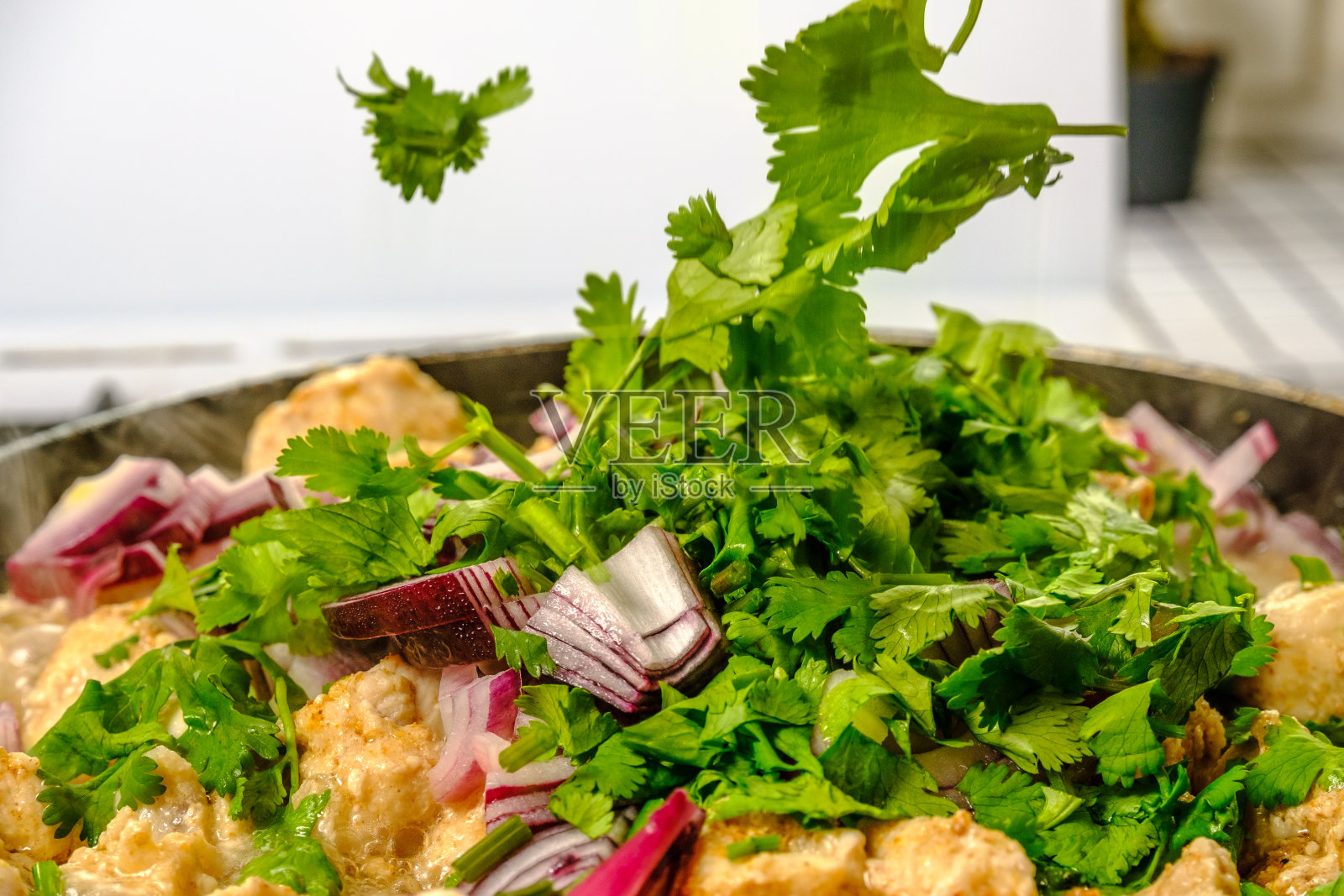 鸡肉、洋葱和香菜的叶子掉进锅里照片摄影图片