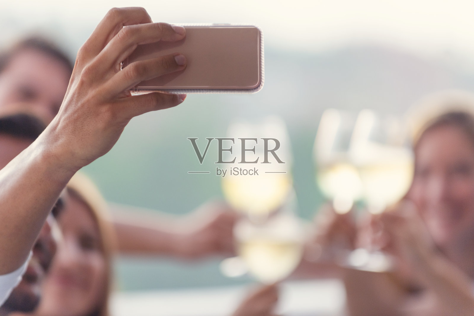 一群朋友在晚宴上用手机自拍。照片摄影图片