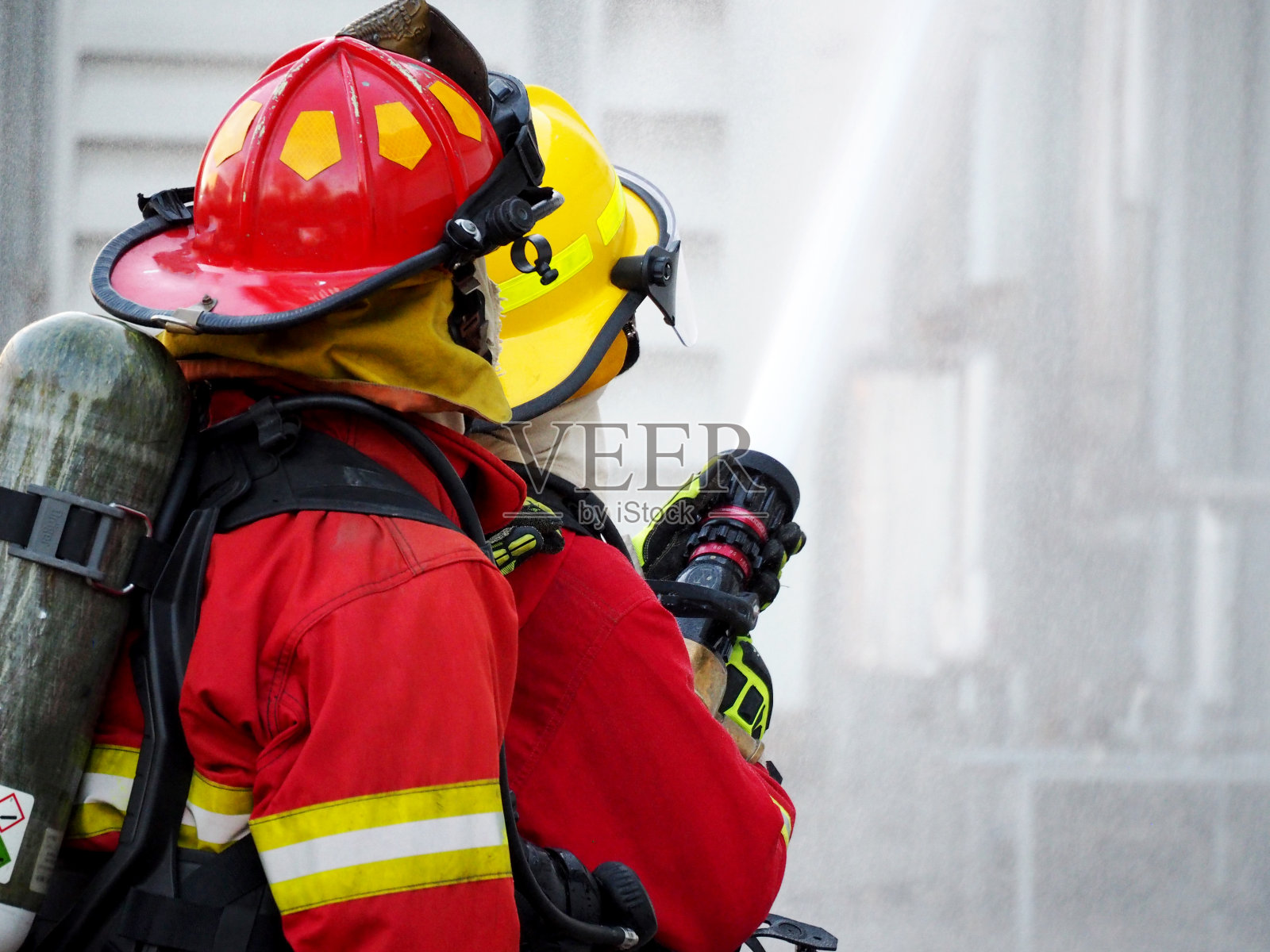 消防队员培训。消防队员用水和灭火器灭火照片摄影图片