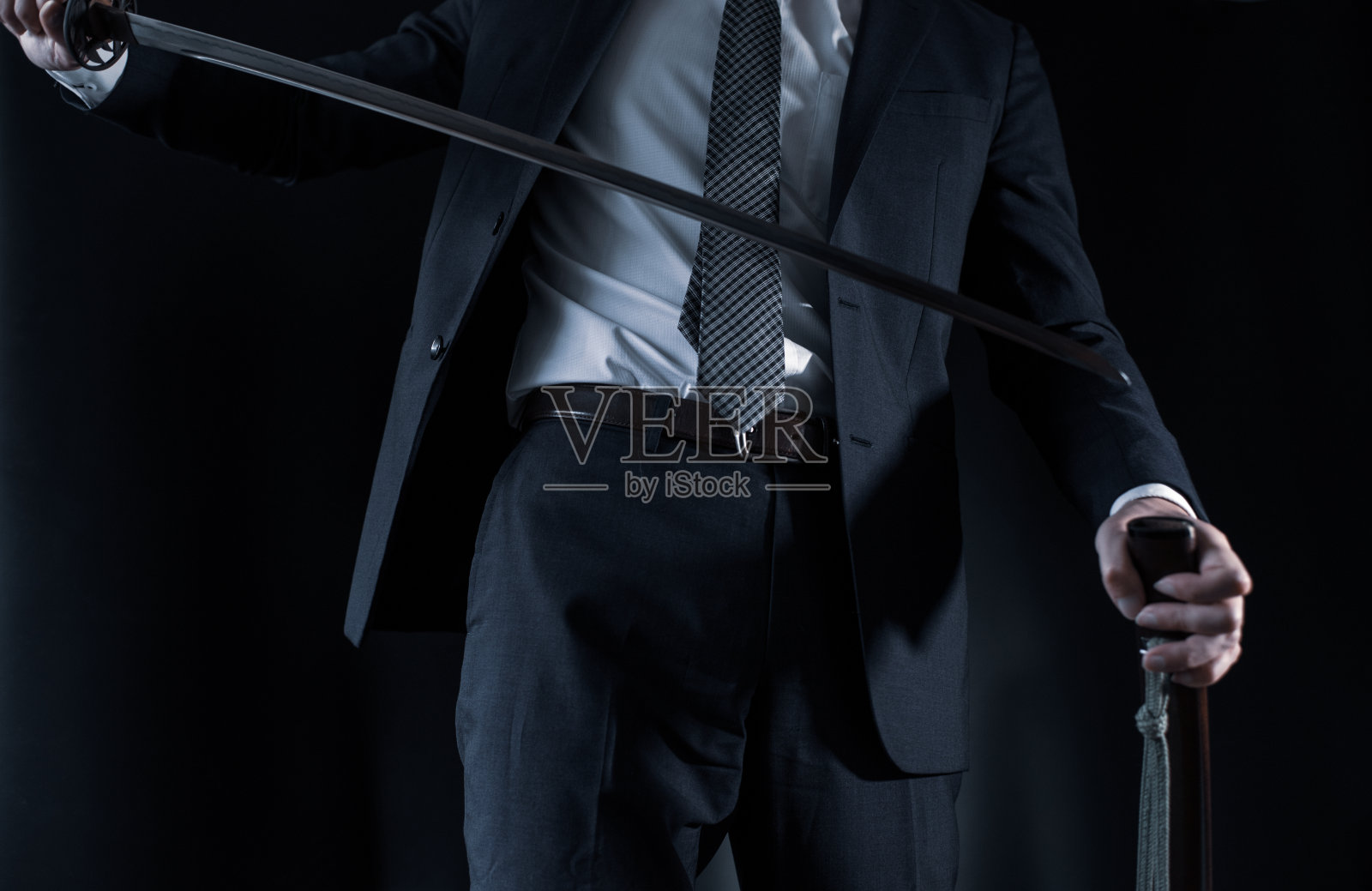 一个穿着西装，手持日本剑的男人照片摄影图片