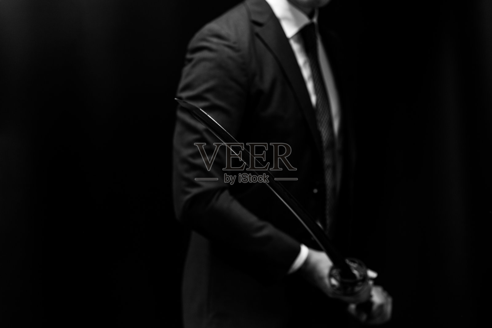 一个穿着西装，手持日本剑的男人照片摄影图片