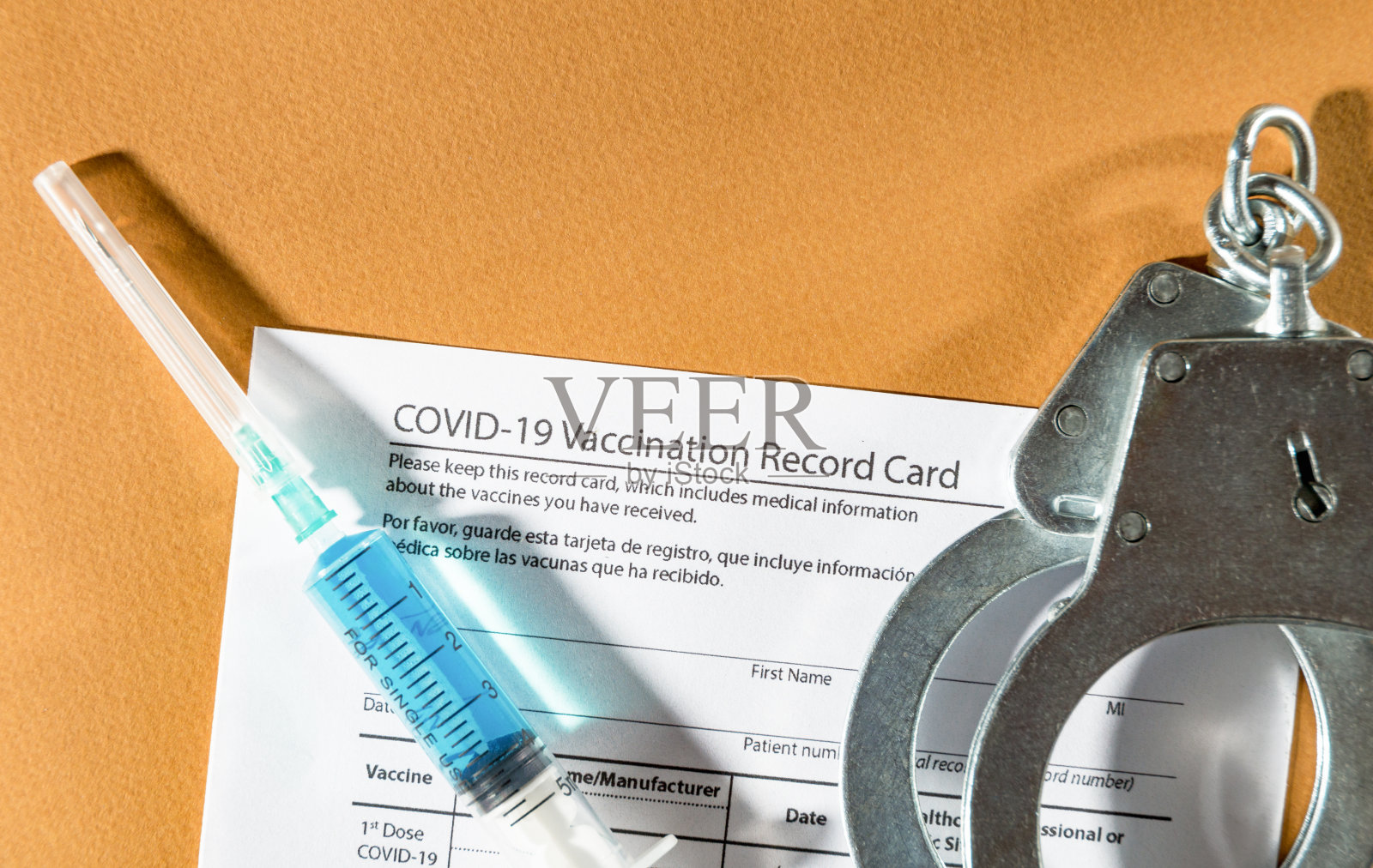 Covid-19疫苗接种记录、注射器和手铐。俯视图照片摄影图片