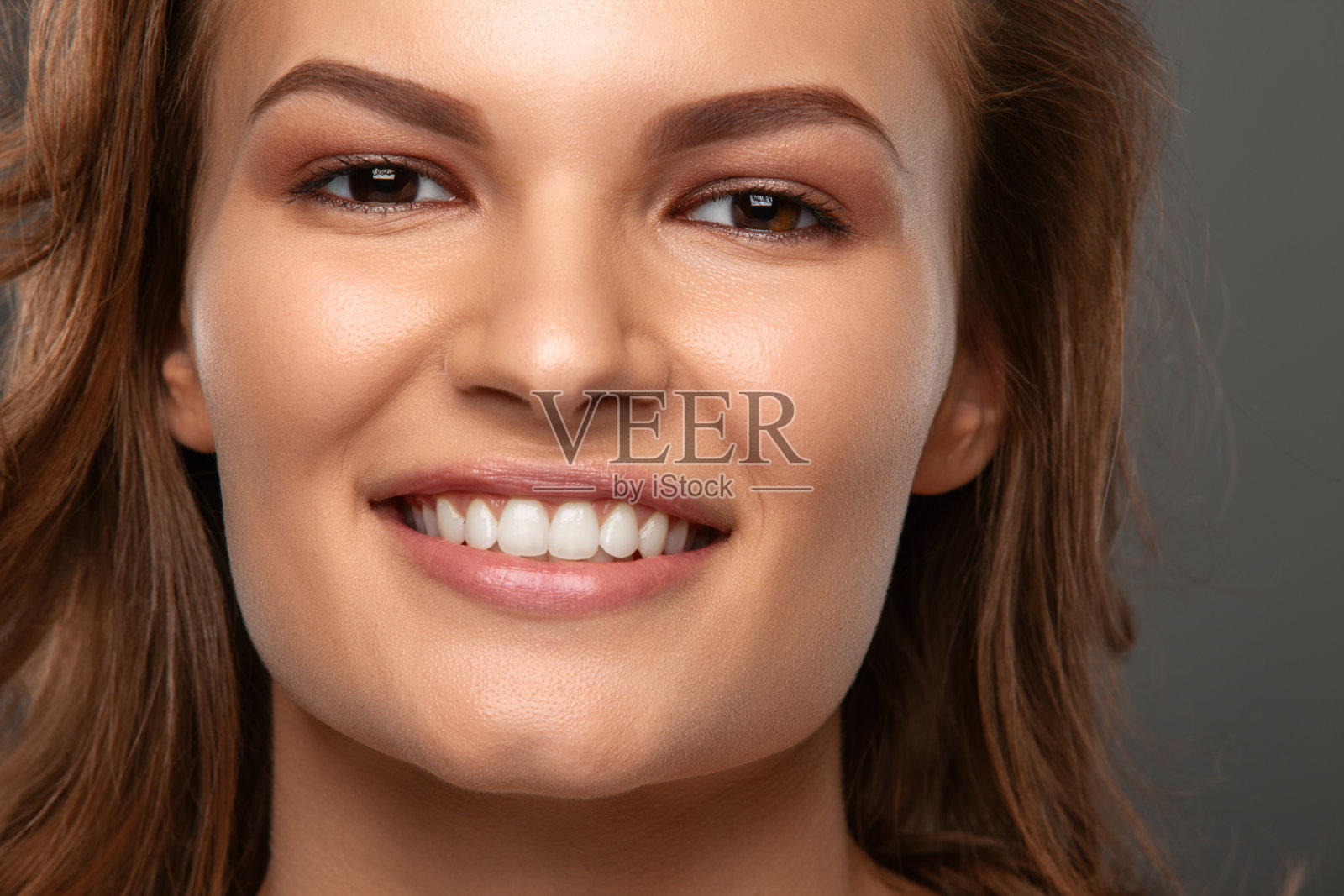 美丽可爱的黑发女孩微笑。工作室肖像。照片摄影图片