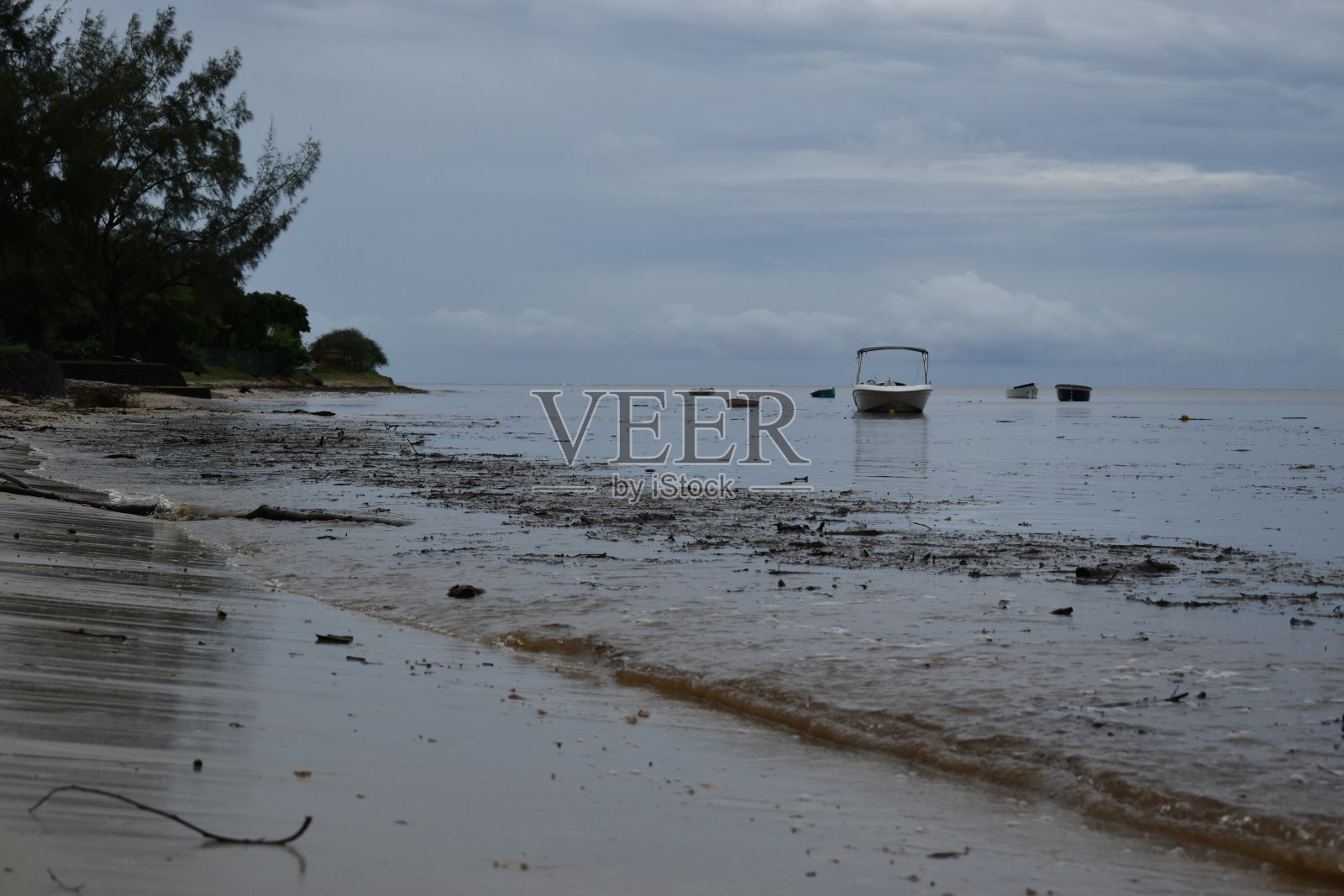 在一系列的突发洪水后，大量的碎片被带回海滩。照片摄影图片