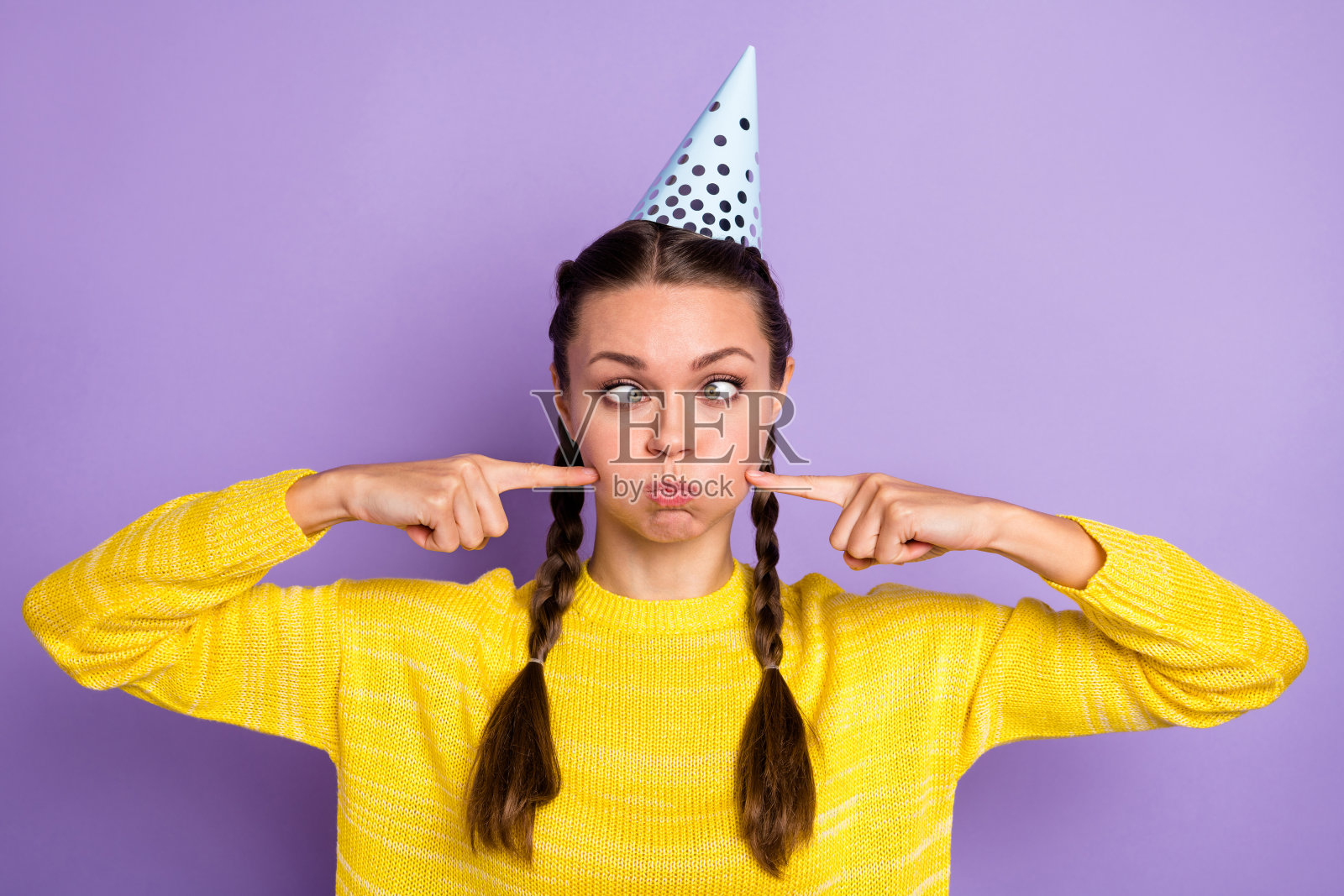 无忧无虑的人的肖像斜视眼睛保持呼吸手指触摸脸颊孤立在紫色的背景照片摄影图片