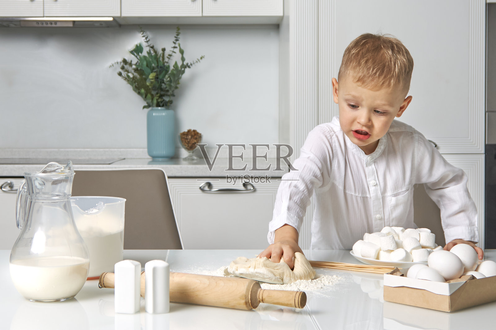 男孩高兴地用面团准备馅饼照片摄影图片