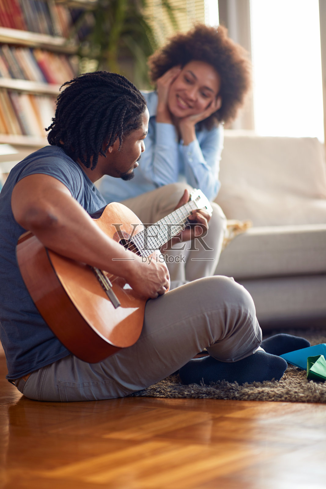 年轻女子在家听丈夫弹吉他。家人，在一起，爱，音乐照片摄影图片