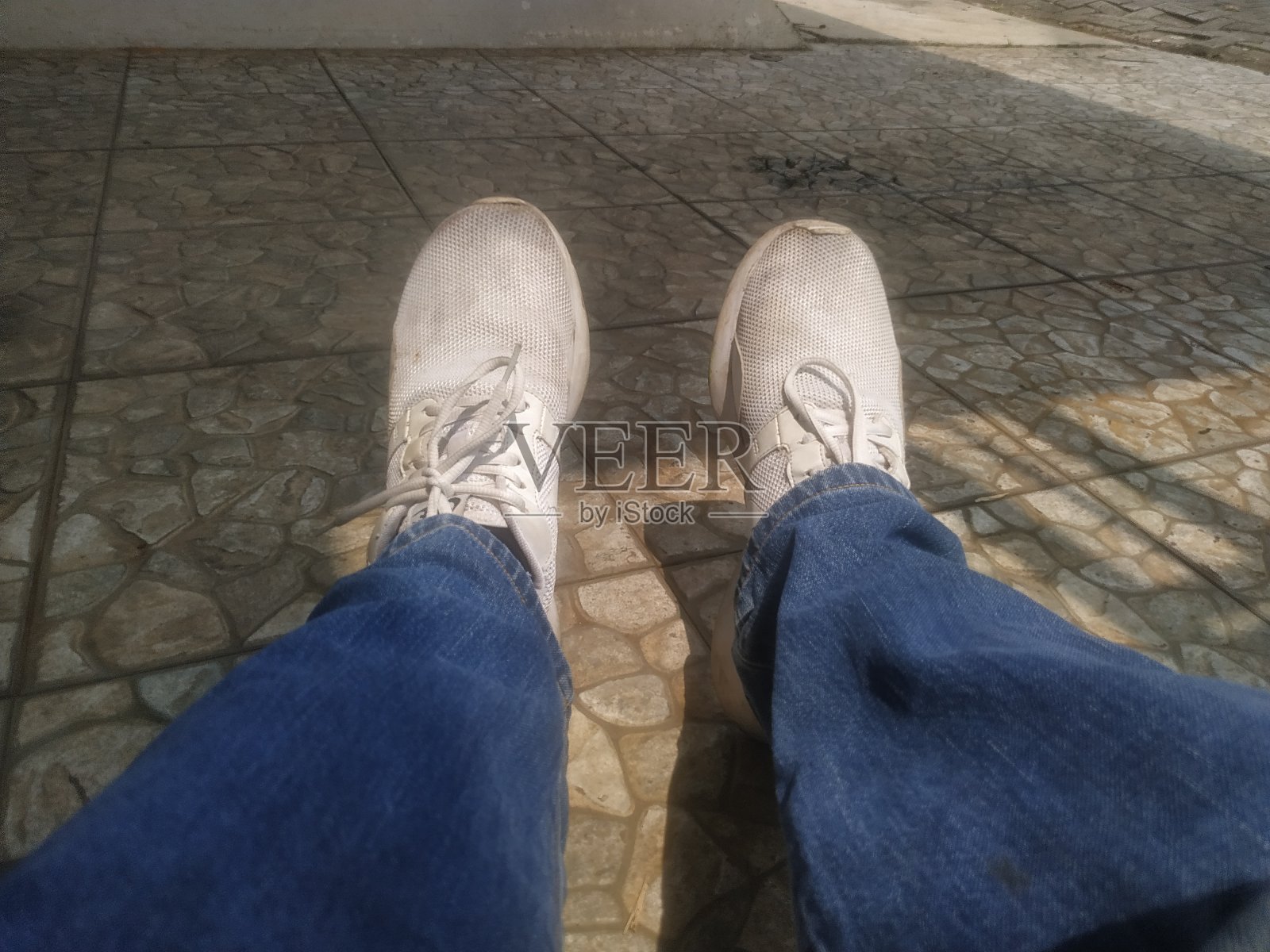 肮脏的白色运动鞋和蓝色牛仔裤照片摄影图片