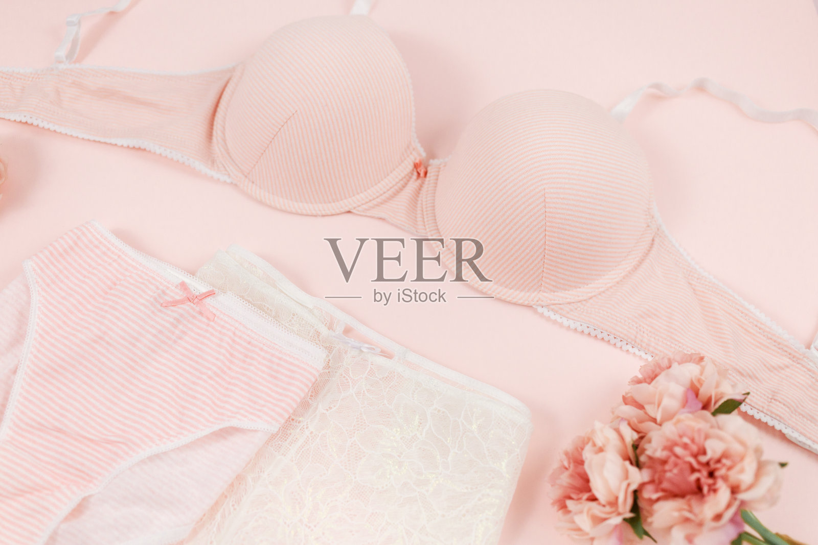 粉色现代女士必备:胸罩和棉质内裤。时尚内衣，女性内衣。蕾丝温柔的内裤和胸罩在淡粉色的背景。美丽，时尚，博客，社交媒体内容照片摄影图片