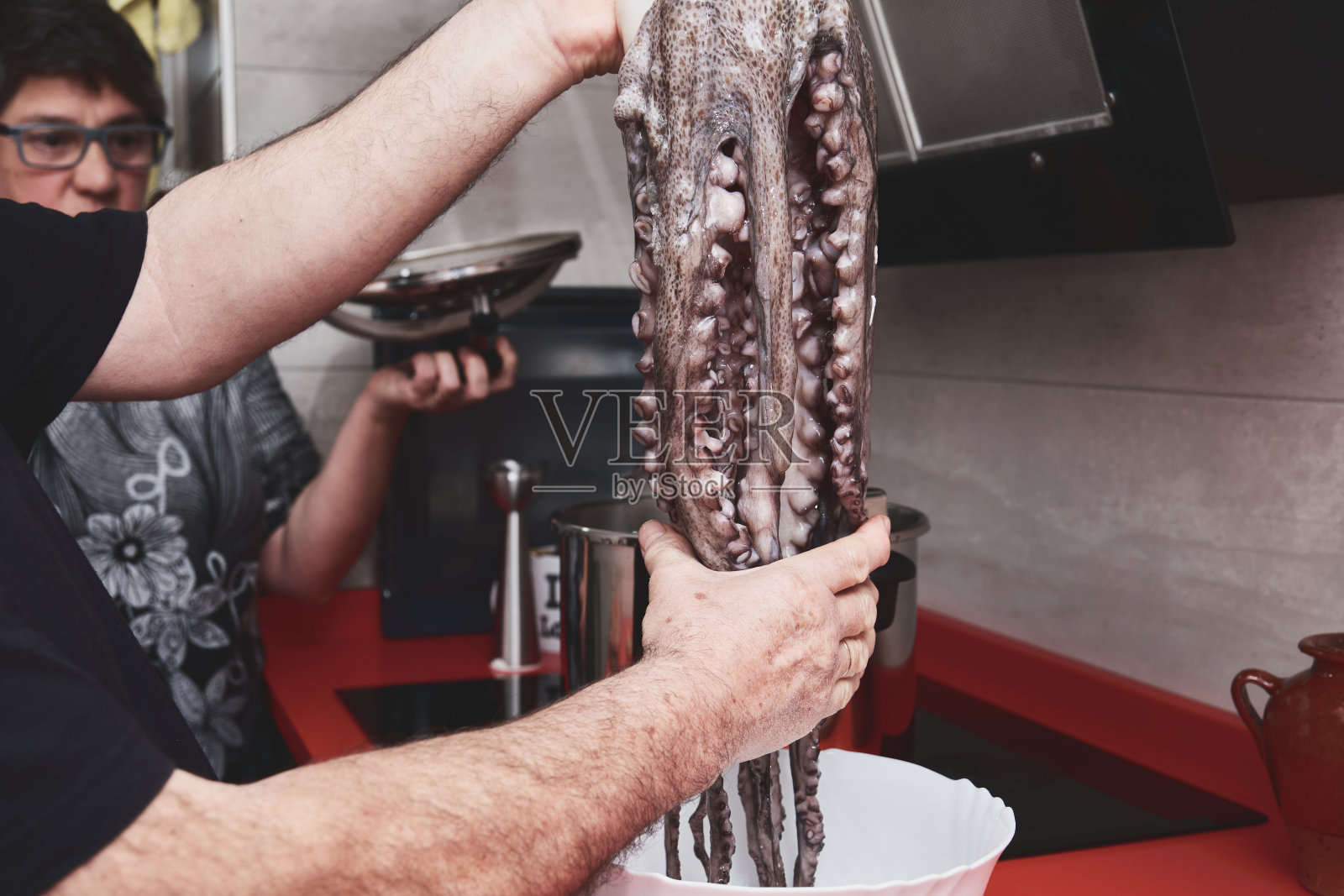 一对白人夫妇准备煮章鱼。男人和女人在做加利西亚章鱼。照片摄影图片