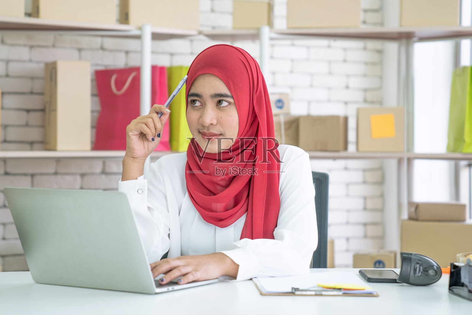 中小企业：亚洲女性小企业主在家工作，现代穆斯林女性，在线业务照片摄影图片