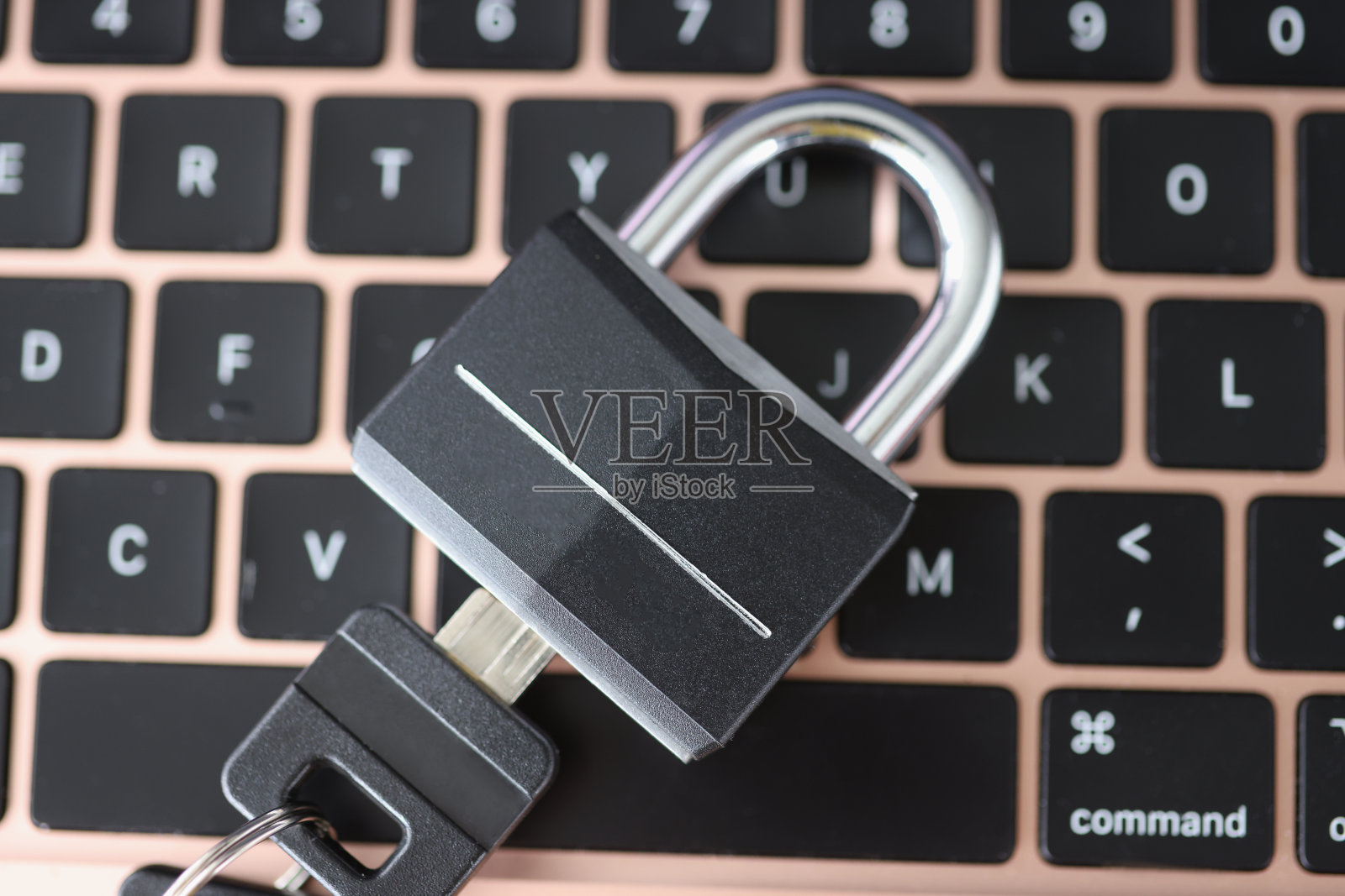 挂锁与钥匙躺在笔记本电脑键盘特写照片摄影图片