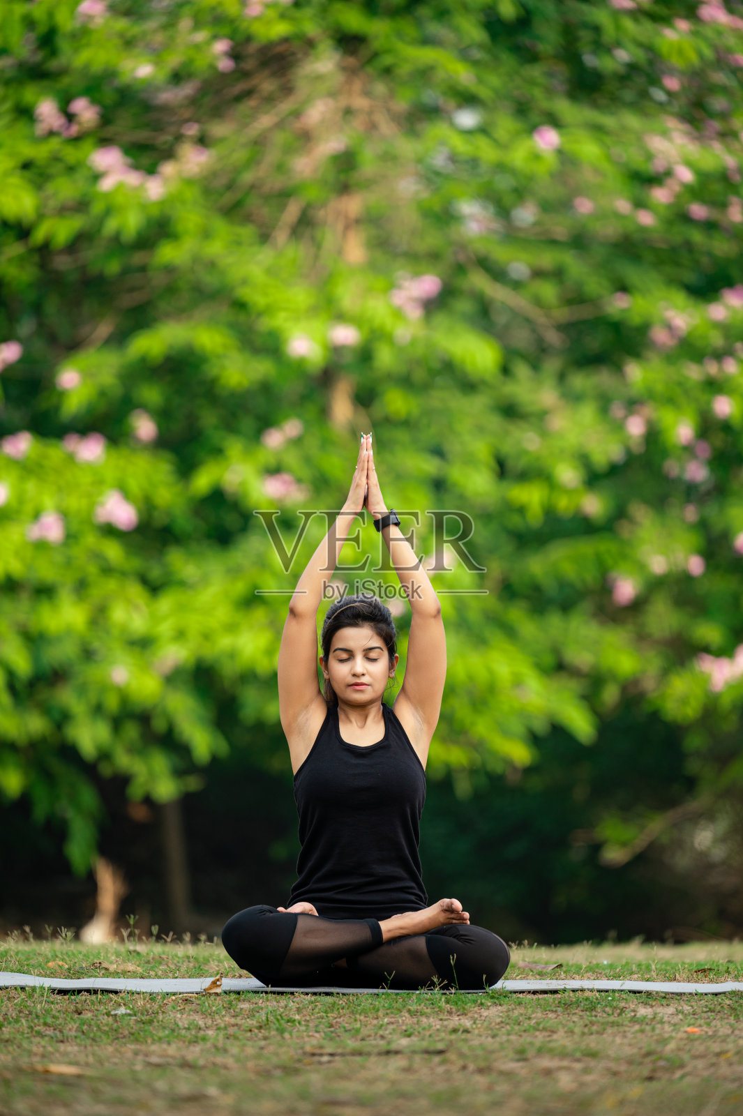 美丽的年轻女子沉思在公园坐莲花的位置照片摄影图片
