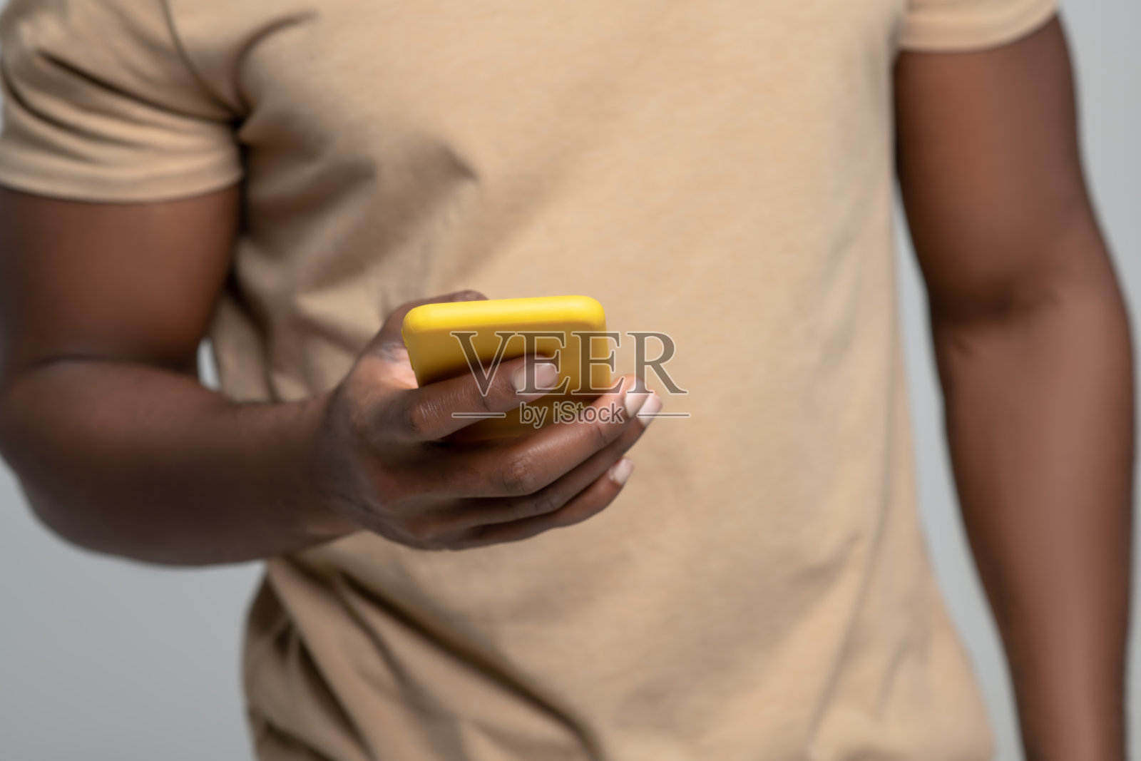 肌肉发达、皮肤黝黑的男子手持智能手机照片摄影图片