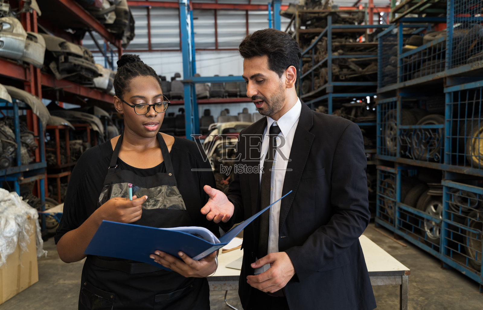 经理的零配件店正在和员工交谈并查看报告。保险代理人正在提供保险和建议的细节，备件商店业主的业务保险概念。照片摄影图片
