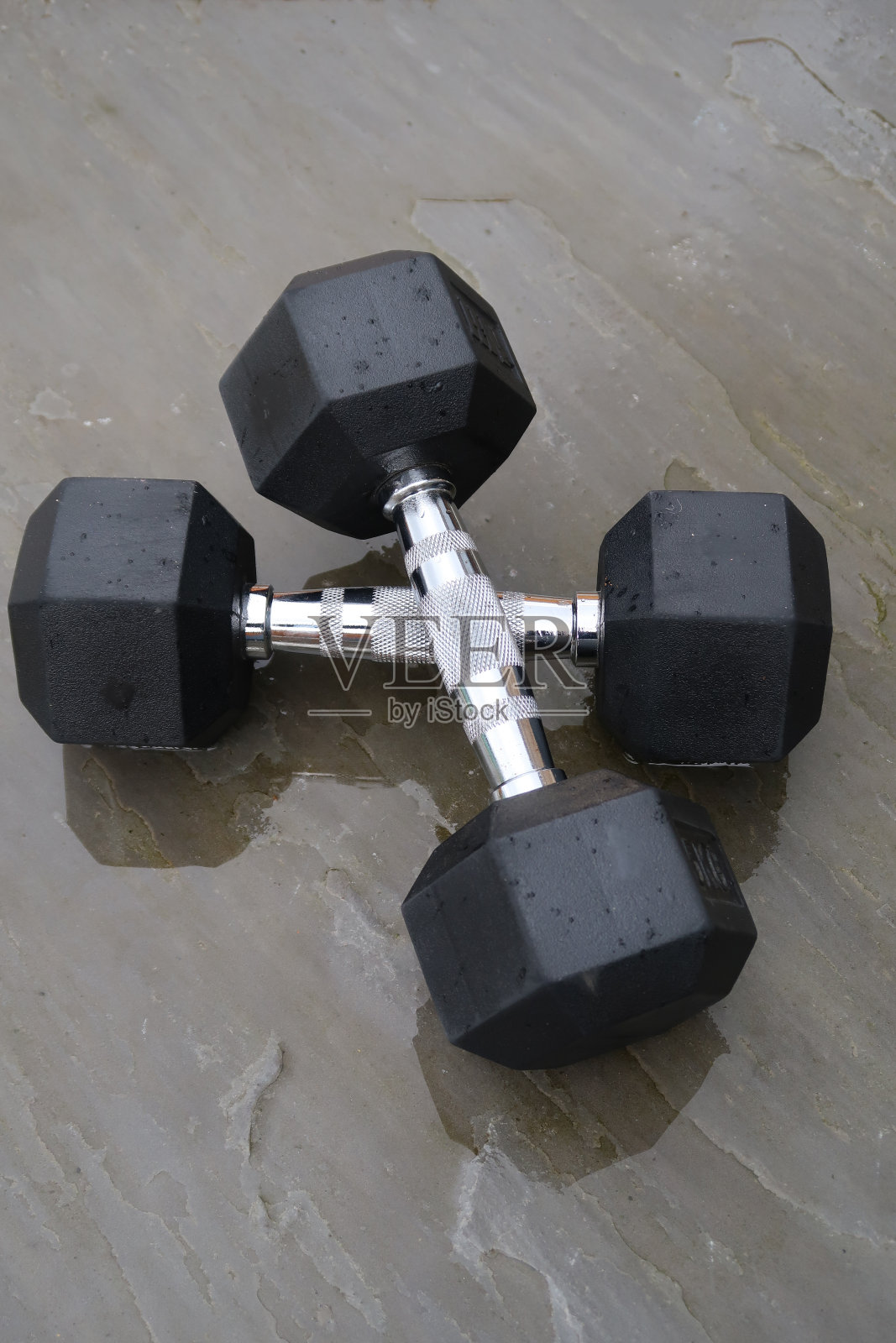 一对六角形哑铃在户外的天井在雨中照片摄影图片