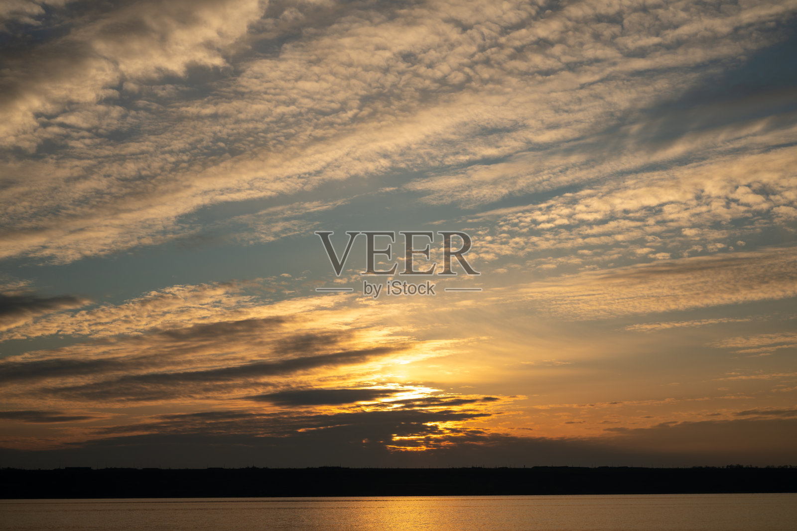 日落时美丽的天空和地平线上的一条细线。创造性的背景。照片摄影图片