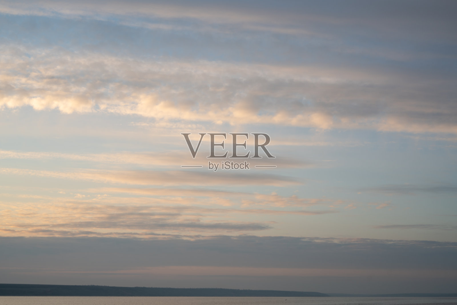 日落时美丽的天空和地平线上的一条细线。创造性的背景。照片摄影图片