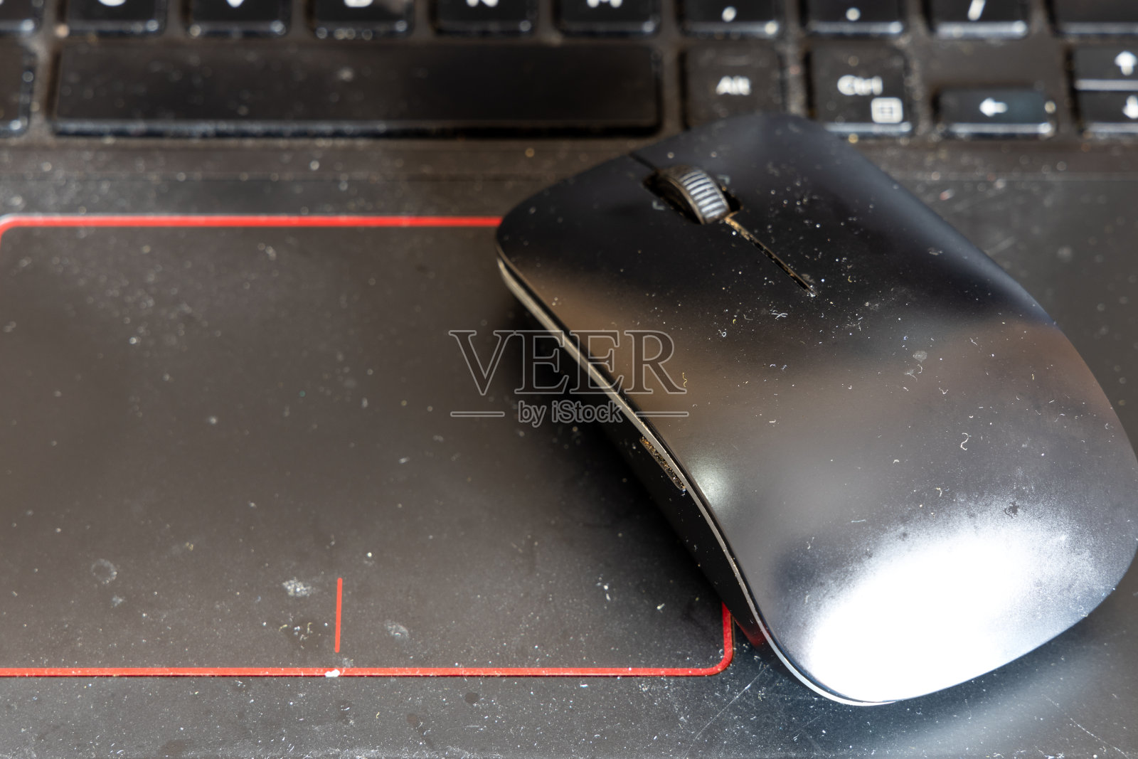 特写肮脏和不卫生的电脑笔记本电脑鼠标和键盘，充满灰尘和颗粒照片摄影图片