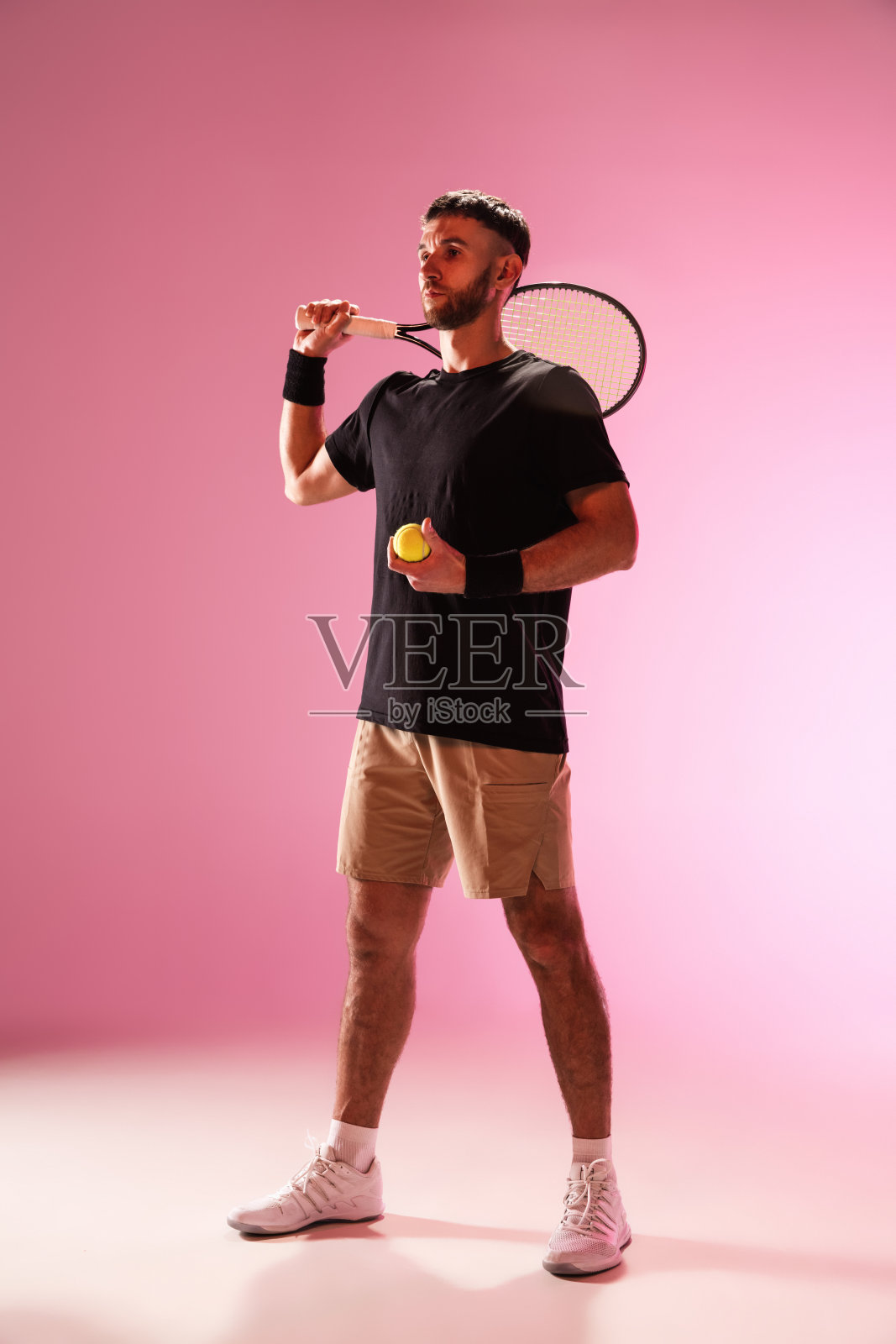 年轻的白人男子打网球孤立在粉红色的工作室背景，动作和运动的概念照片摄影图片