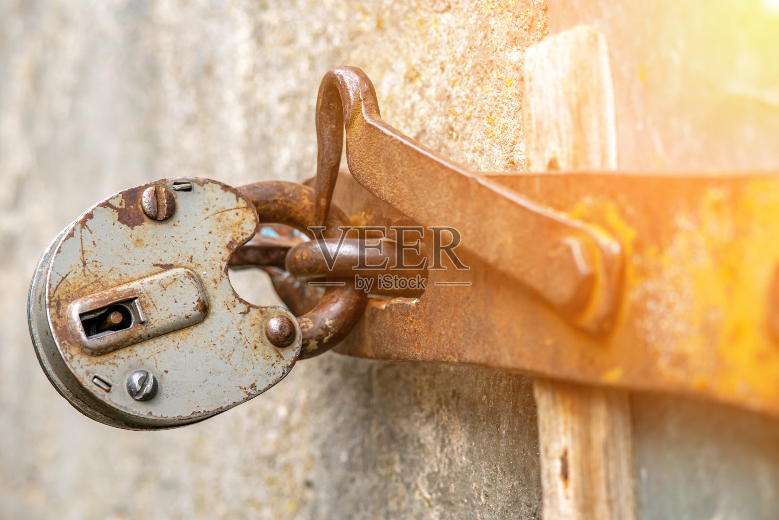 挂锁挂在门上。在生锈的门铰链上的大谷仓锁。照片摄影图片