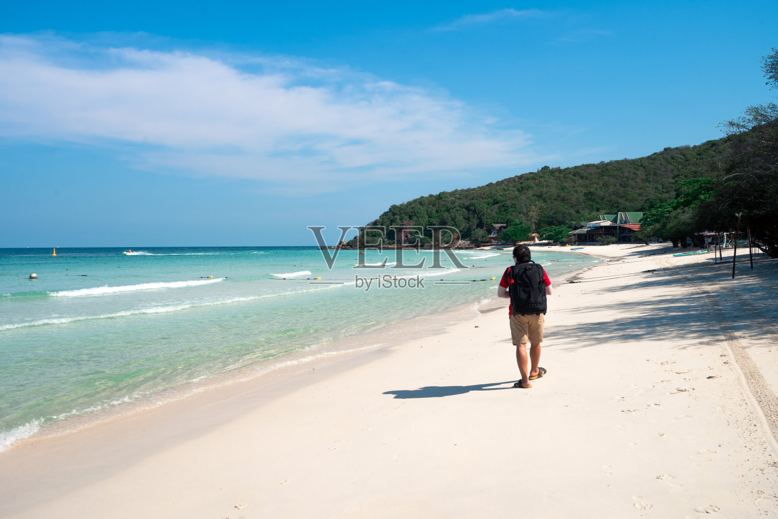 湛蓝的大海，晴朗的天空，白色的沙滩，山岛上的背包客在沙滩上行走照片摄影图片