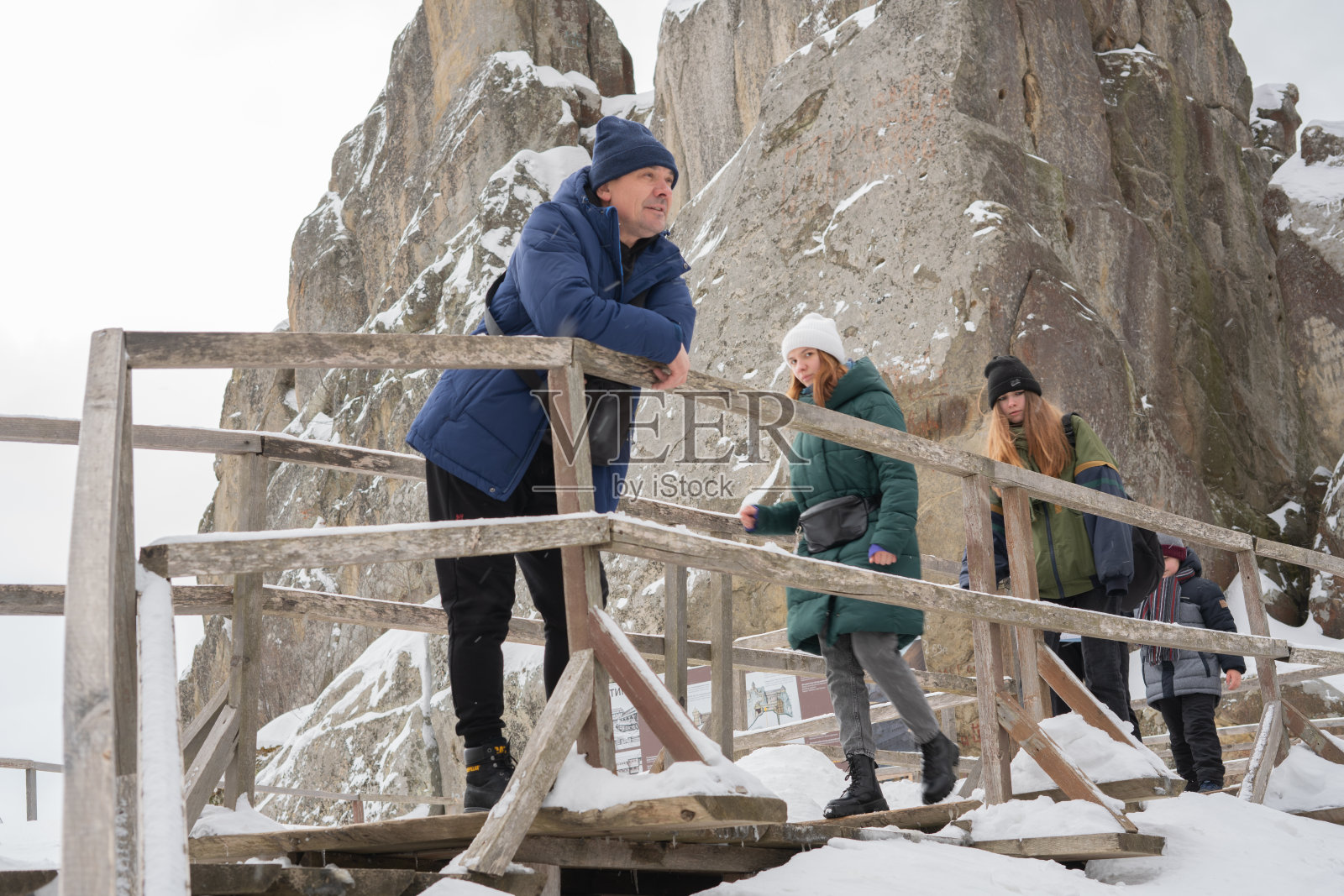 在被雪覆盖的山上徒步旅行的一个游客家庭。有选择性的重点。Tustan。喀尔巴阡山。乌克兰。照片摄影图片