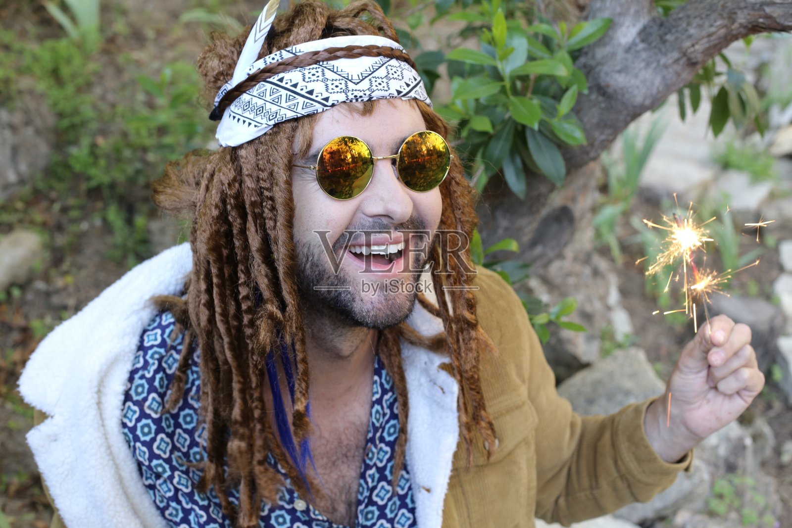 年轻的波西米亚男子用烟花庆祝照片摄影图片