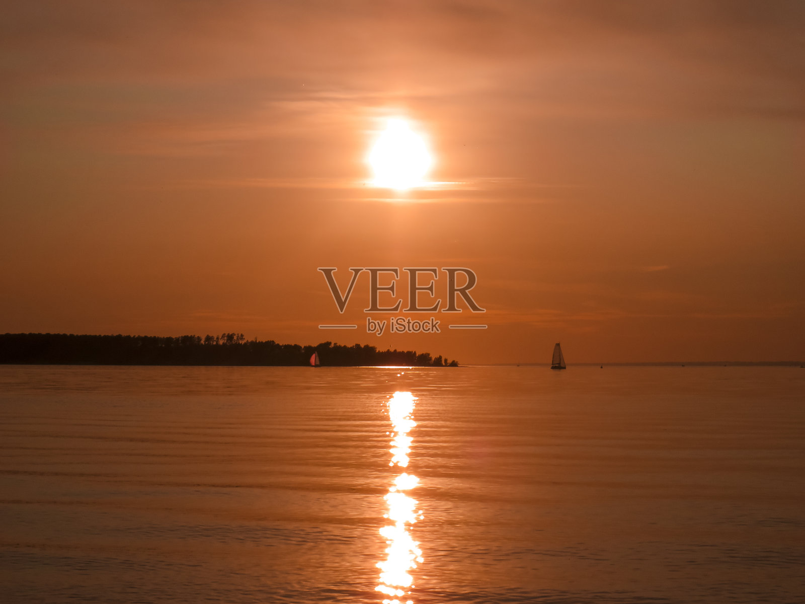 日落时在海上航行的游艇照片摄影图片