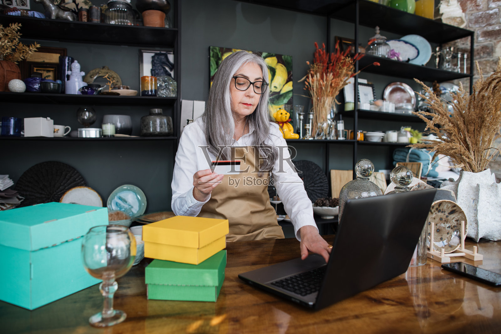 售货员在商店的笔记本电脑上登记折扣卡照片摄影图片