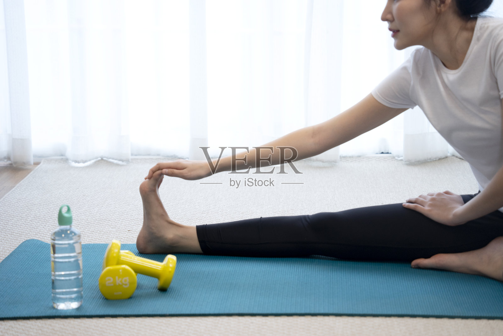 年轻的亚洲女人伸展在瑜伽垫上照片摄影图片