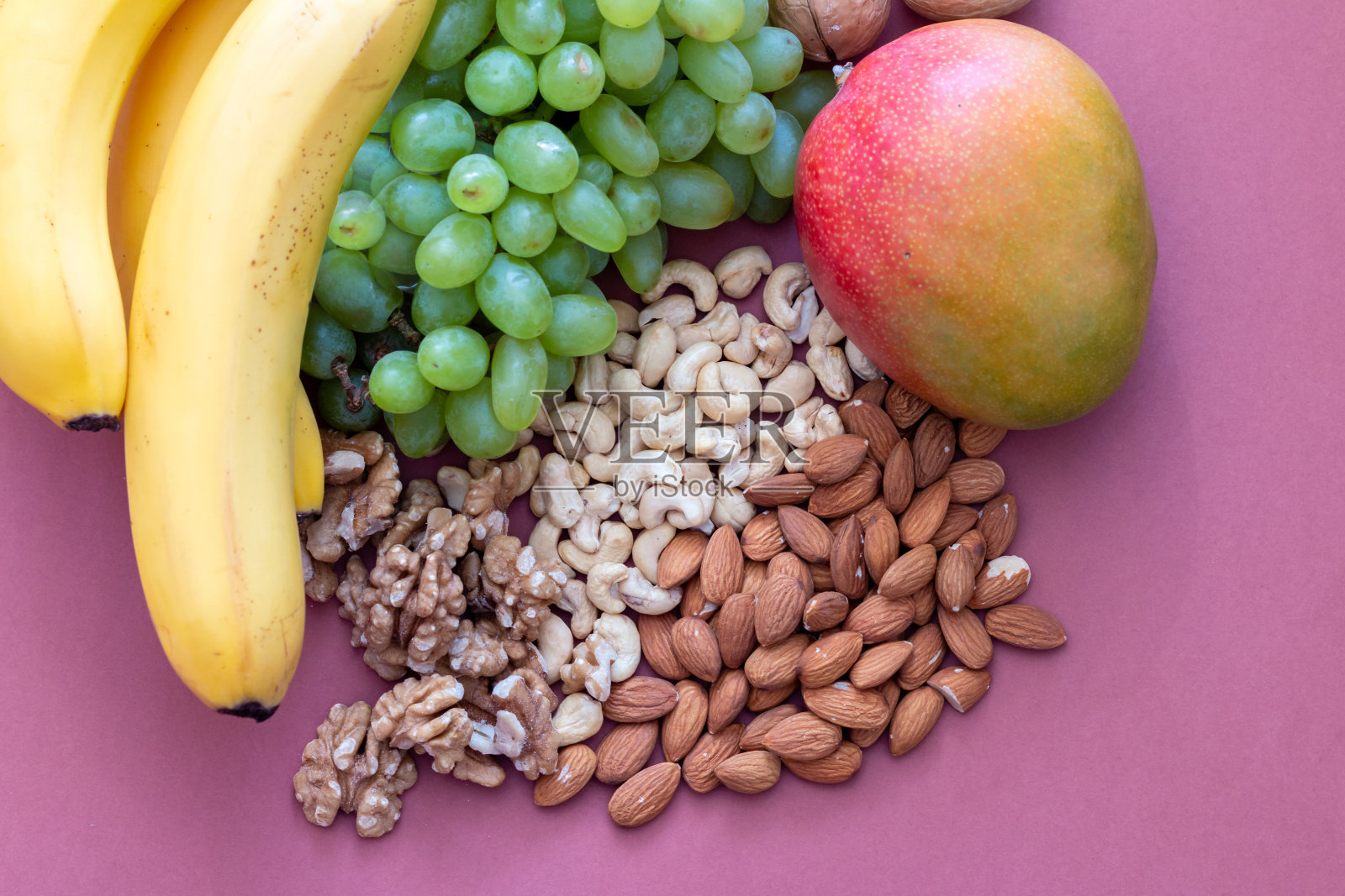 新鲜的绿色葡萄，香蕉，芒果和坚果从上面看照片摄影图片