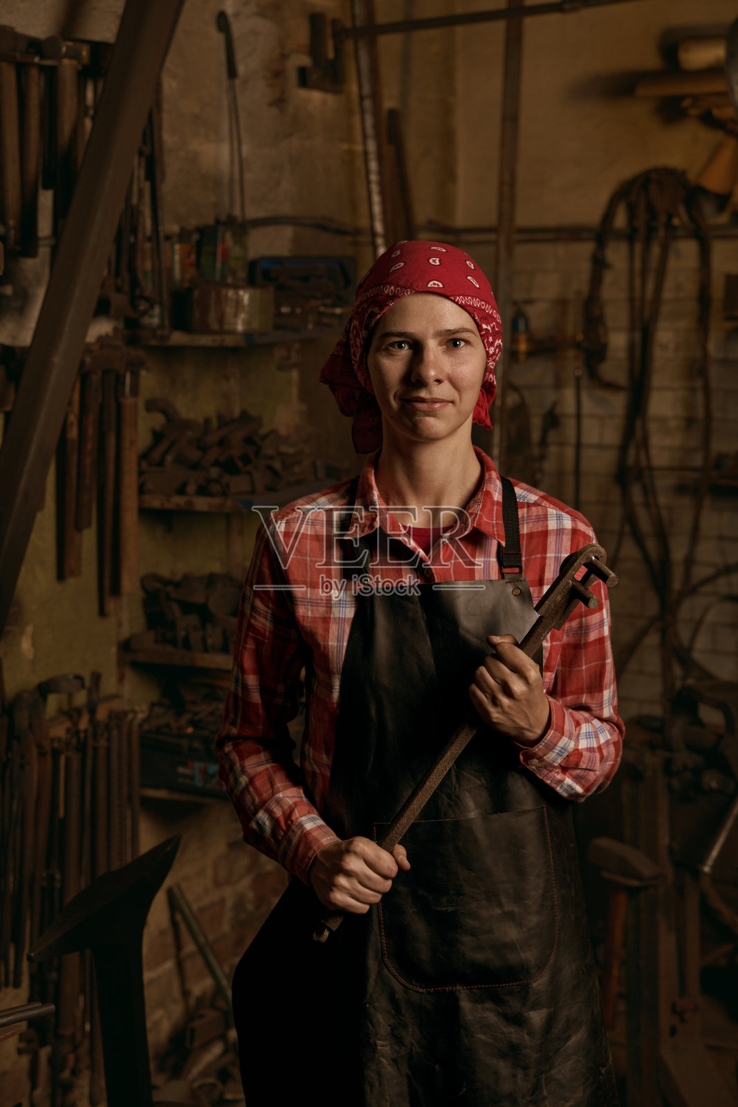 车间里有金属零件的女铁匠照片摄影图片