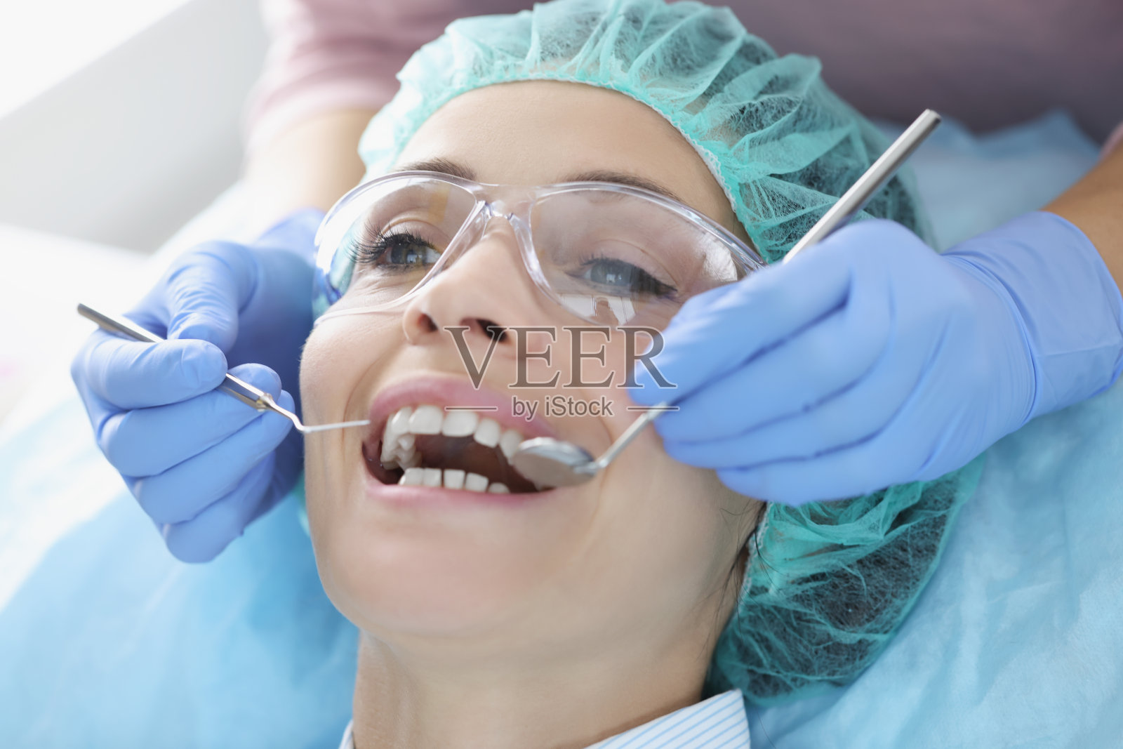 牙科医生正在检查女病人的口腔照片摄影图片