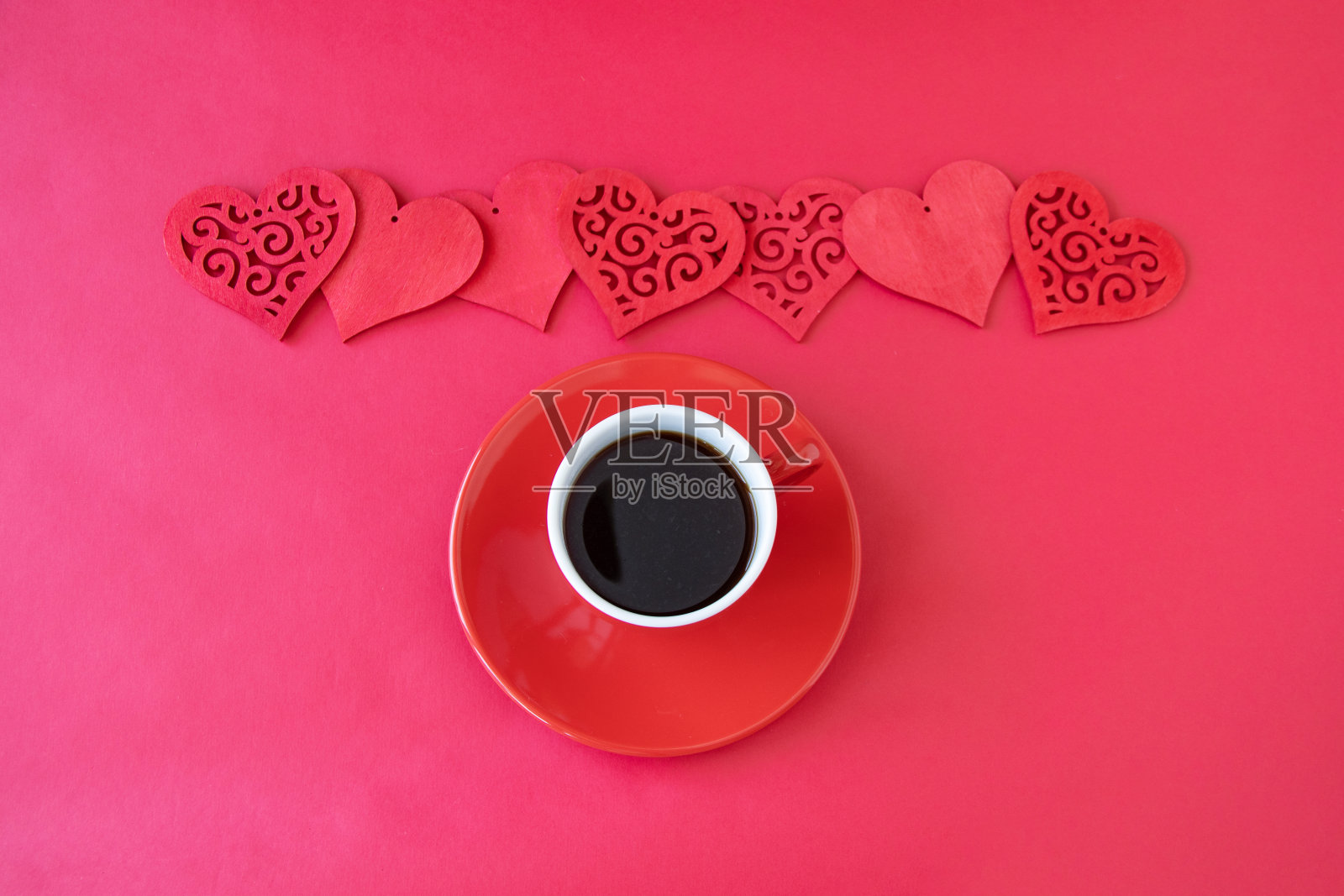 红色背景上的咖啡和红心照片摄影图片