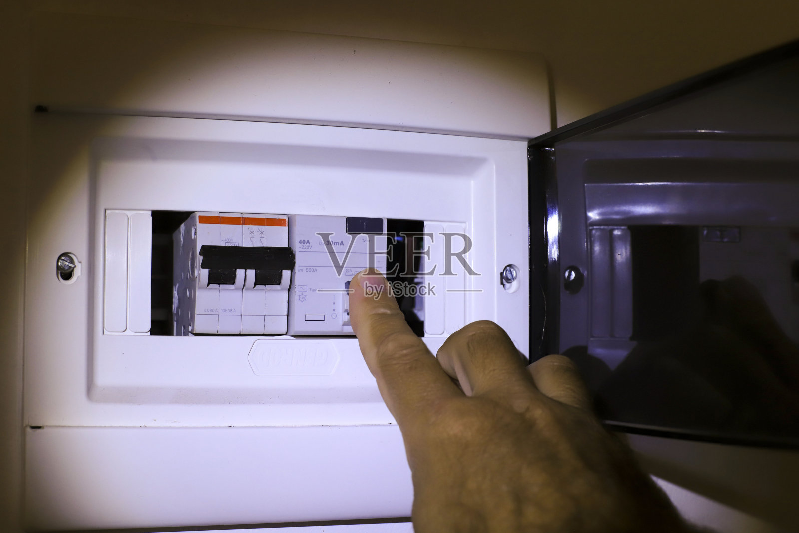 男子的手通过将光键设置在电源板上，断电后。照片摄影图片