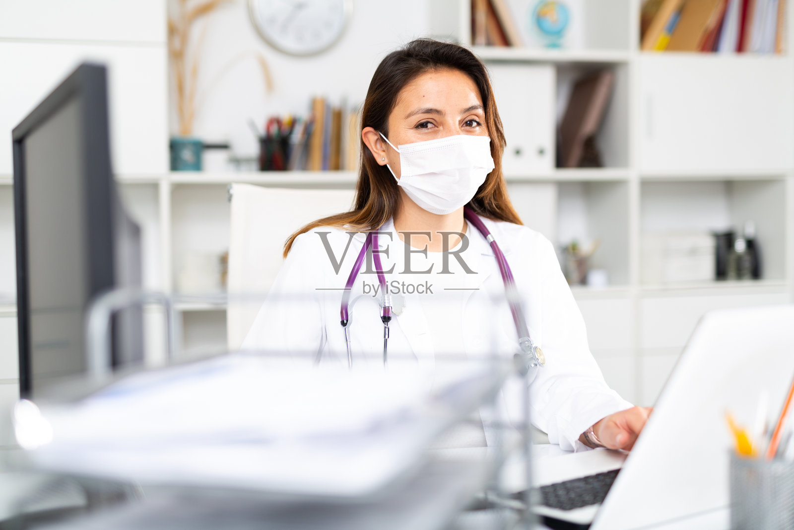 一名年轻女医生在办公室电脑前工作的肖像照片摄影图片