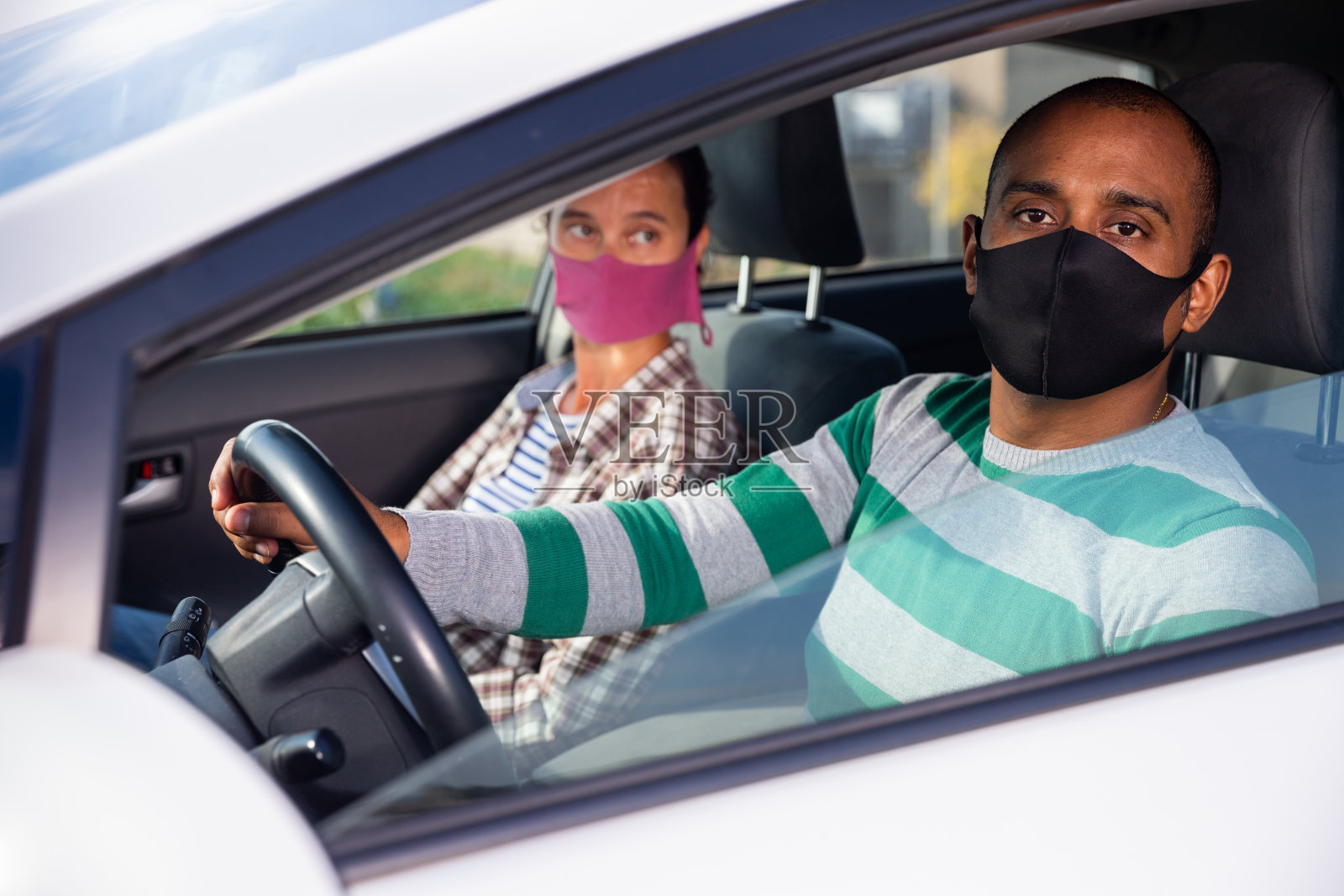 戴着防护面具的夫妇在车里的肖像照片摄影图片