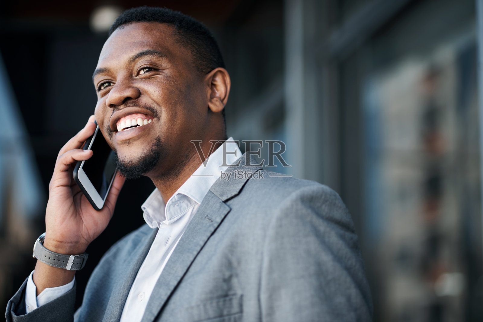 一个年轻英俊的商人白天独自站在外面用手机照片摄影图片